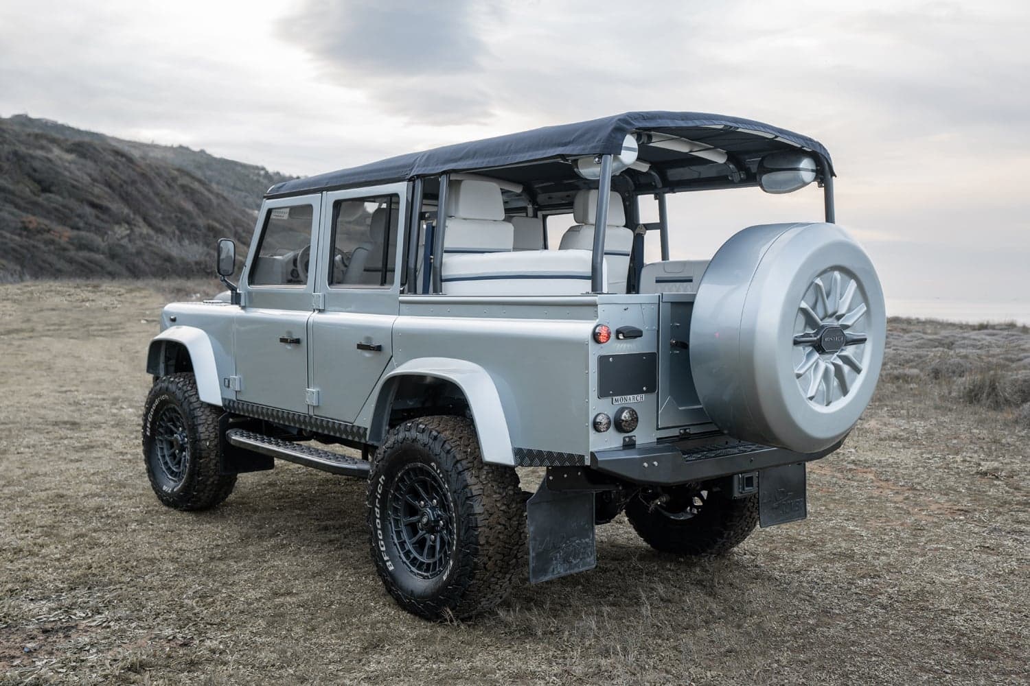 Rear view of a custom Land Rover Defender with a soft top and premium interior