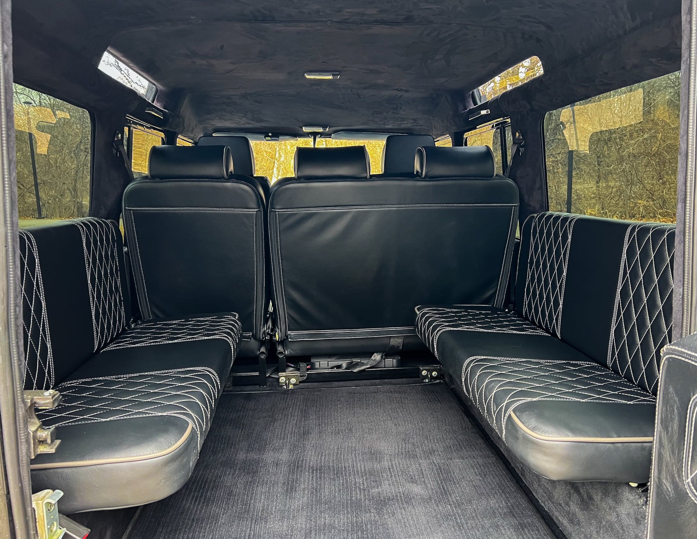 Interior view of a luxury Land Rover Defender with black quilted leather seating