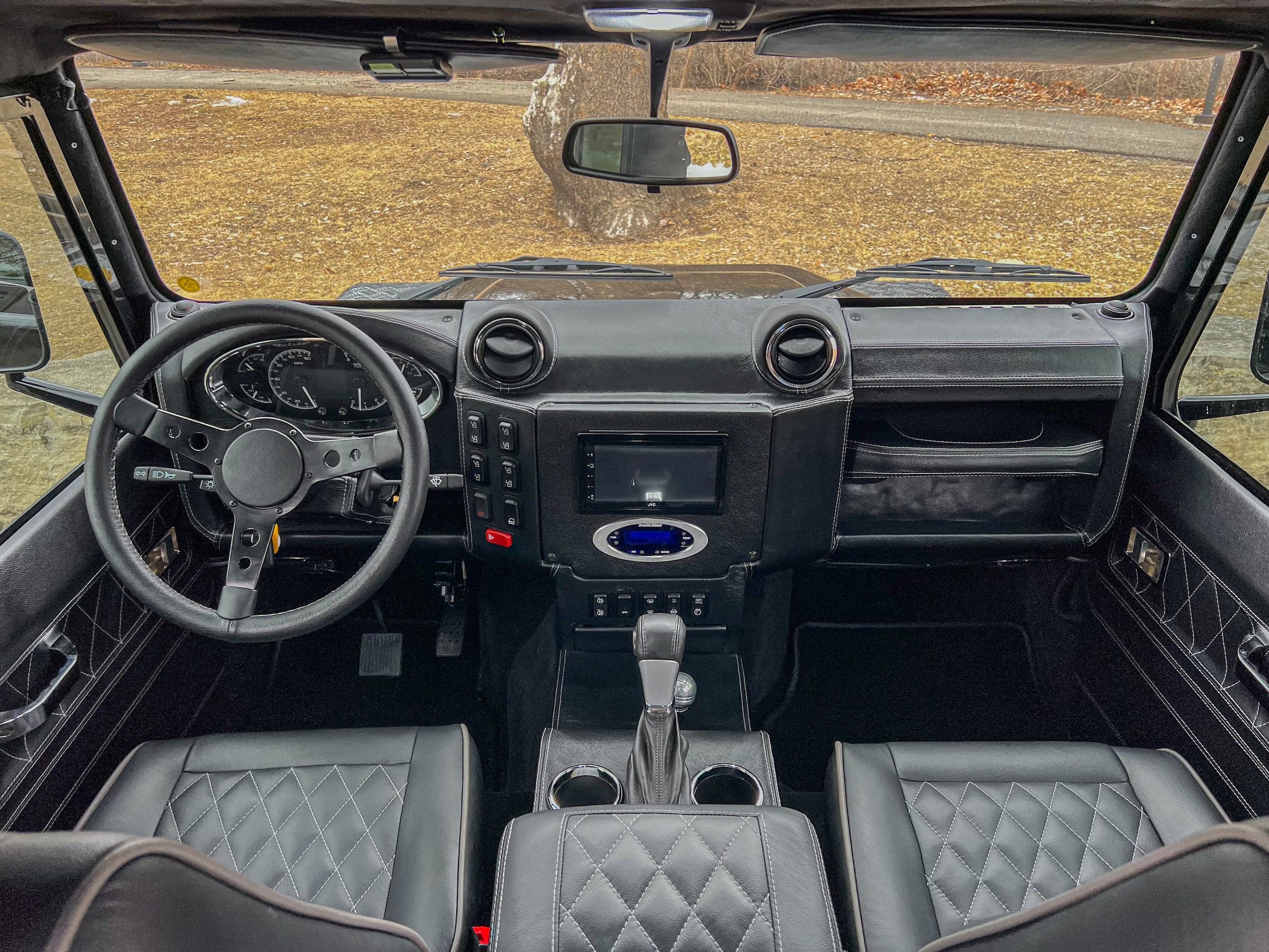Bespoke Land Rover Defender interior featuring premium black leather seats and modern dashboard