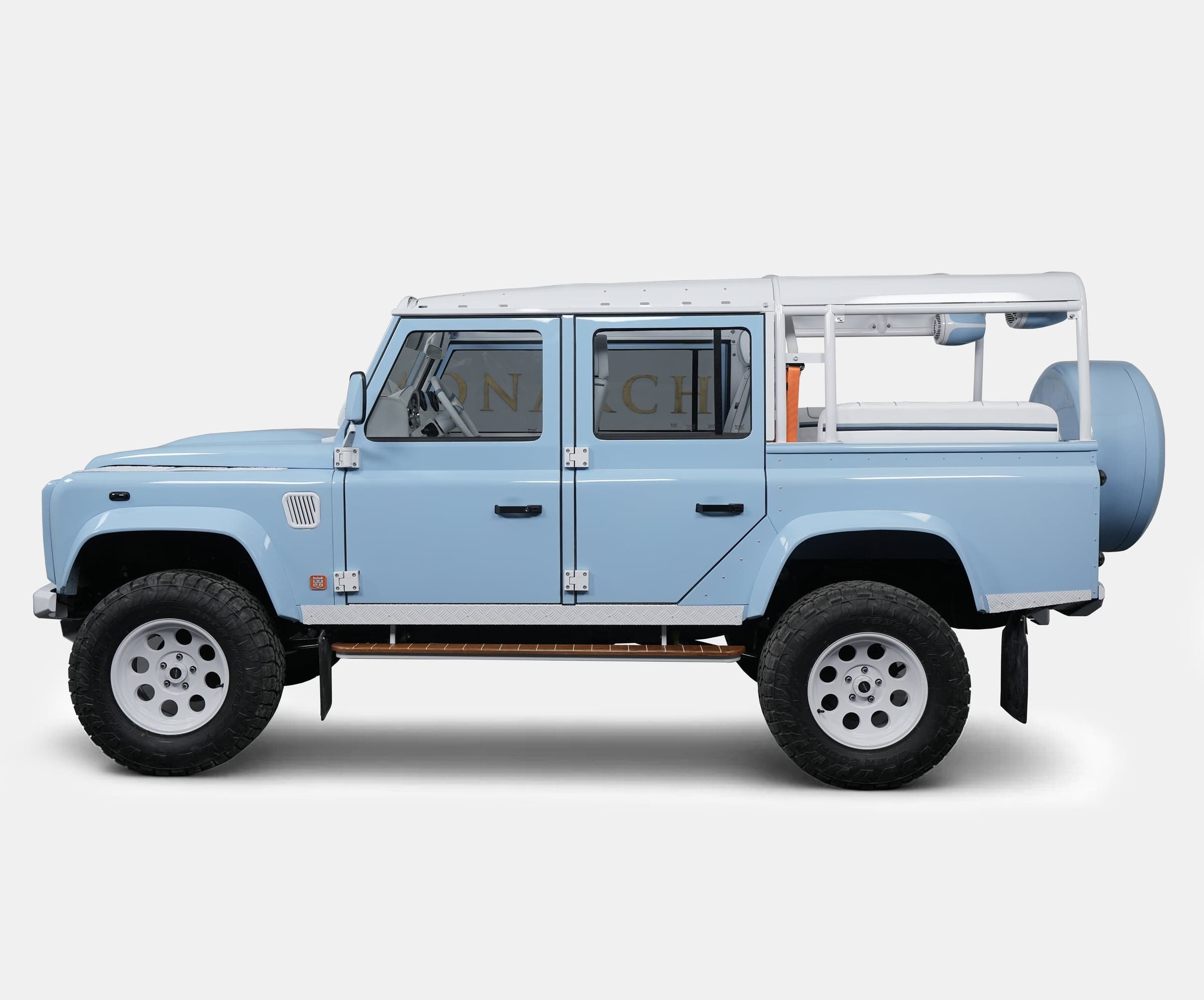 Custom Land Rover Defender in light blue with a white roll cage and off-road tires
