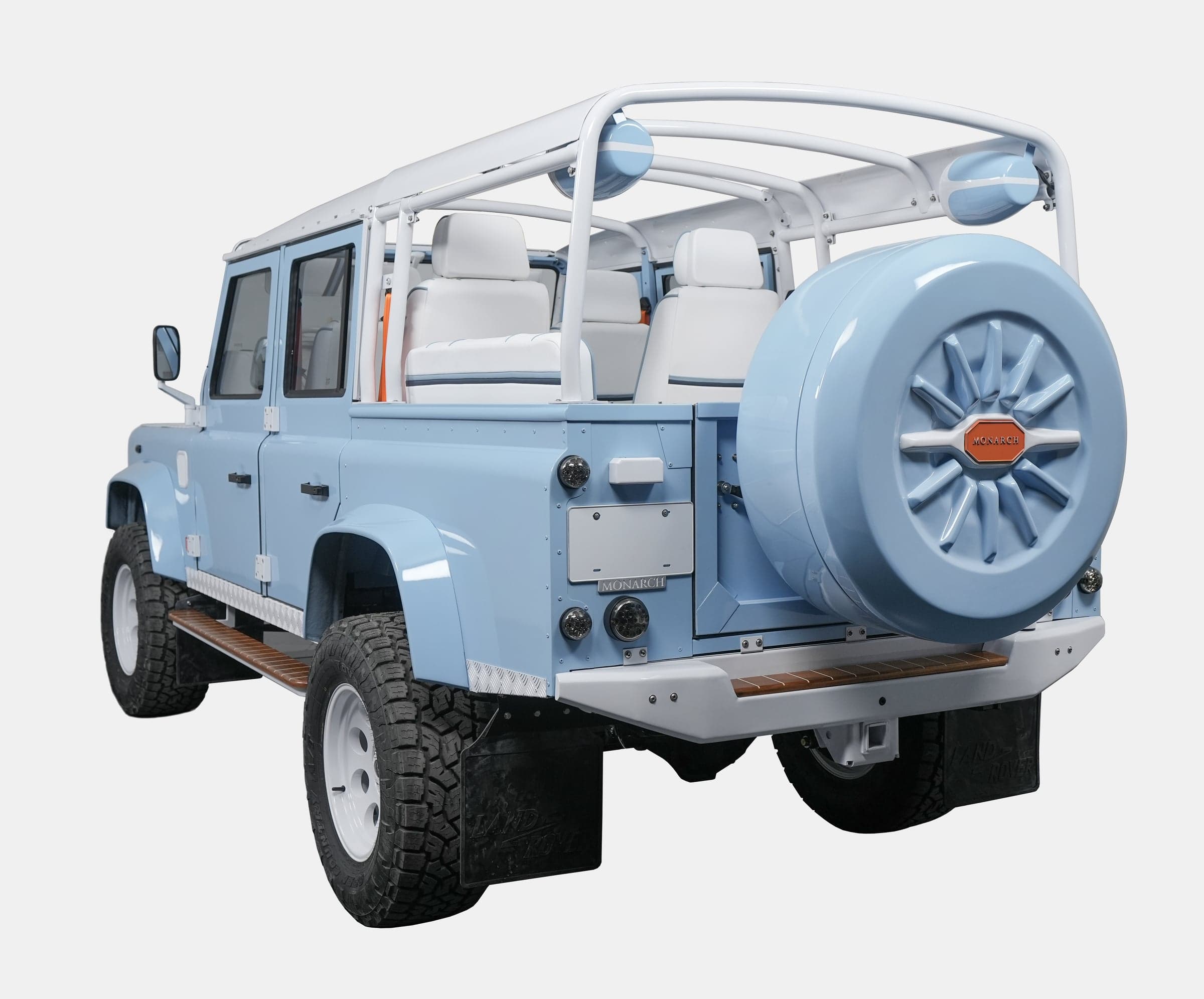 Rear view of a custom blue Land Rover Defender with white interior and unique styling features
