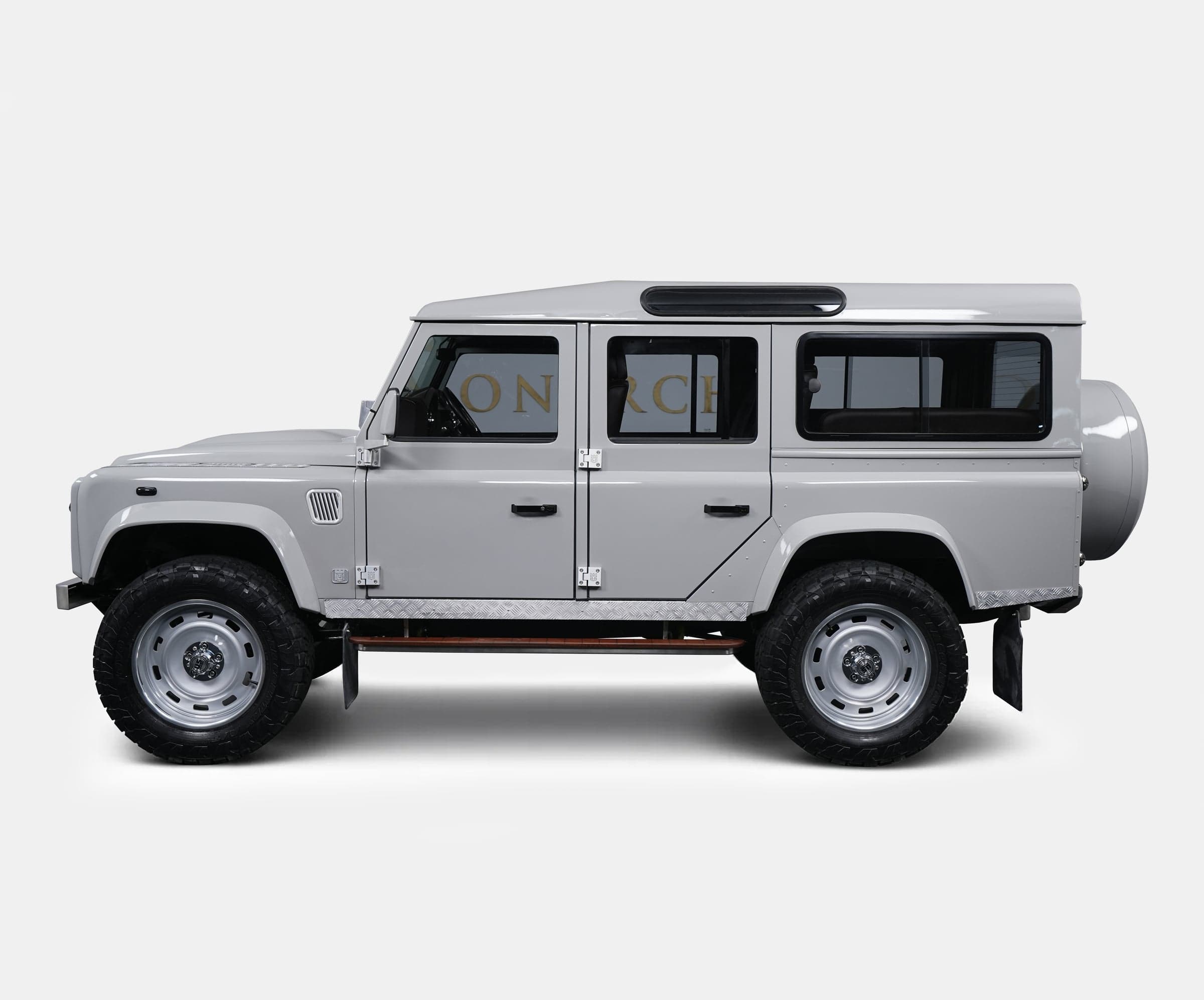 Side view of a bespoke Land Rover Defender in a sleek gray finish with off-road tires