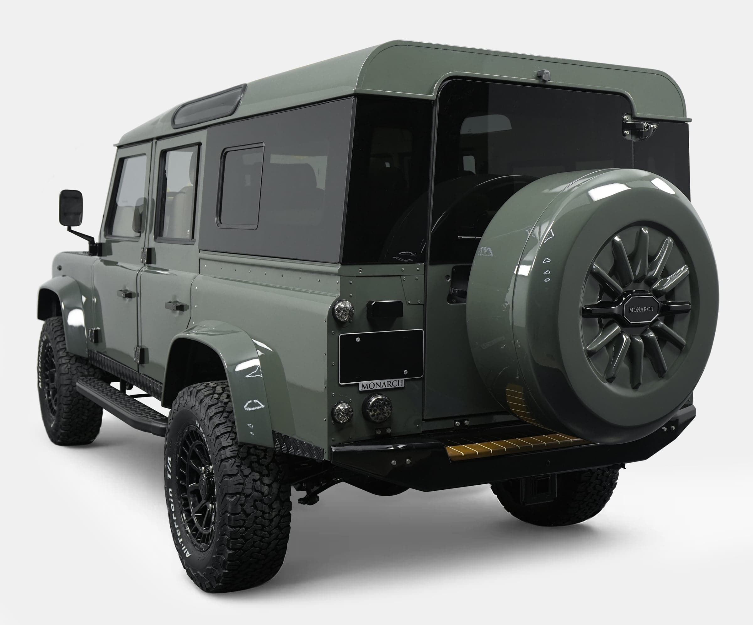 Rear view of a custom Land Rover Defender in green with premium off-road tires
