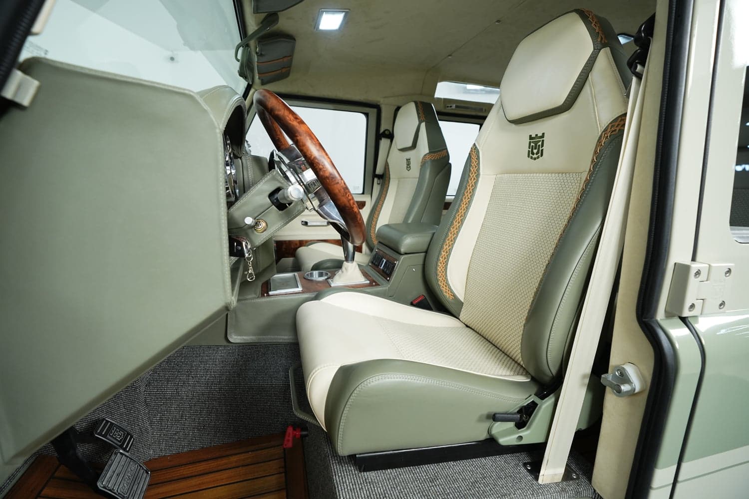 Interior view of a luxury custom Land Rover Defender featuring elegant seats and steering wheel.