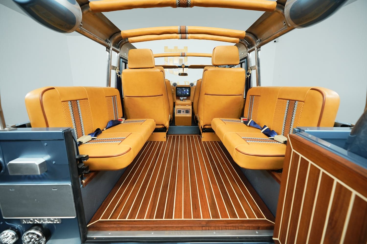 Interior view of a bespoke Land Rover Defender showcasing luxury seating and elegant wood flooring