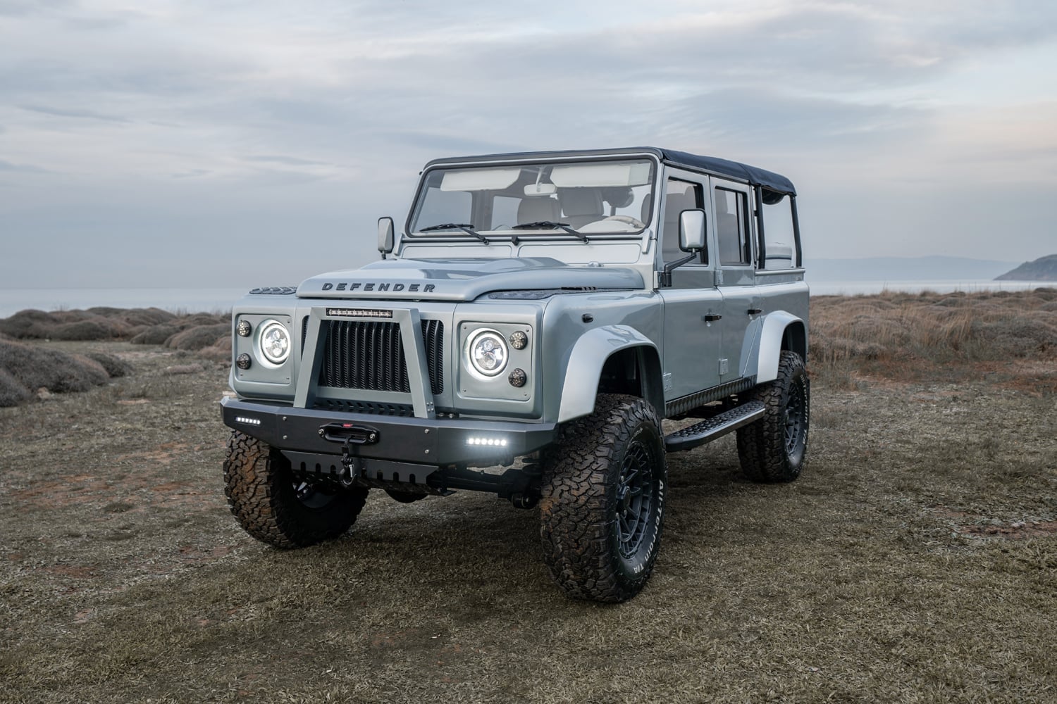 Front view of a luxury custom Land Rover Defender in a natural setting