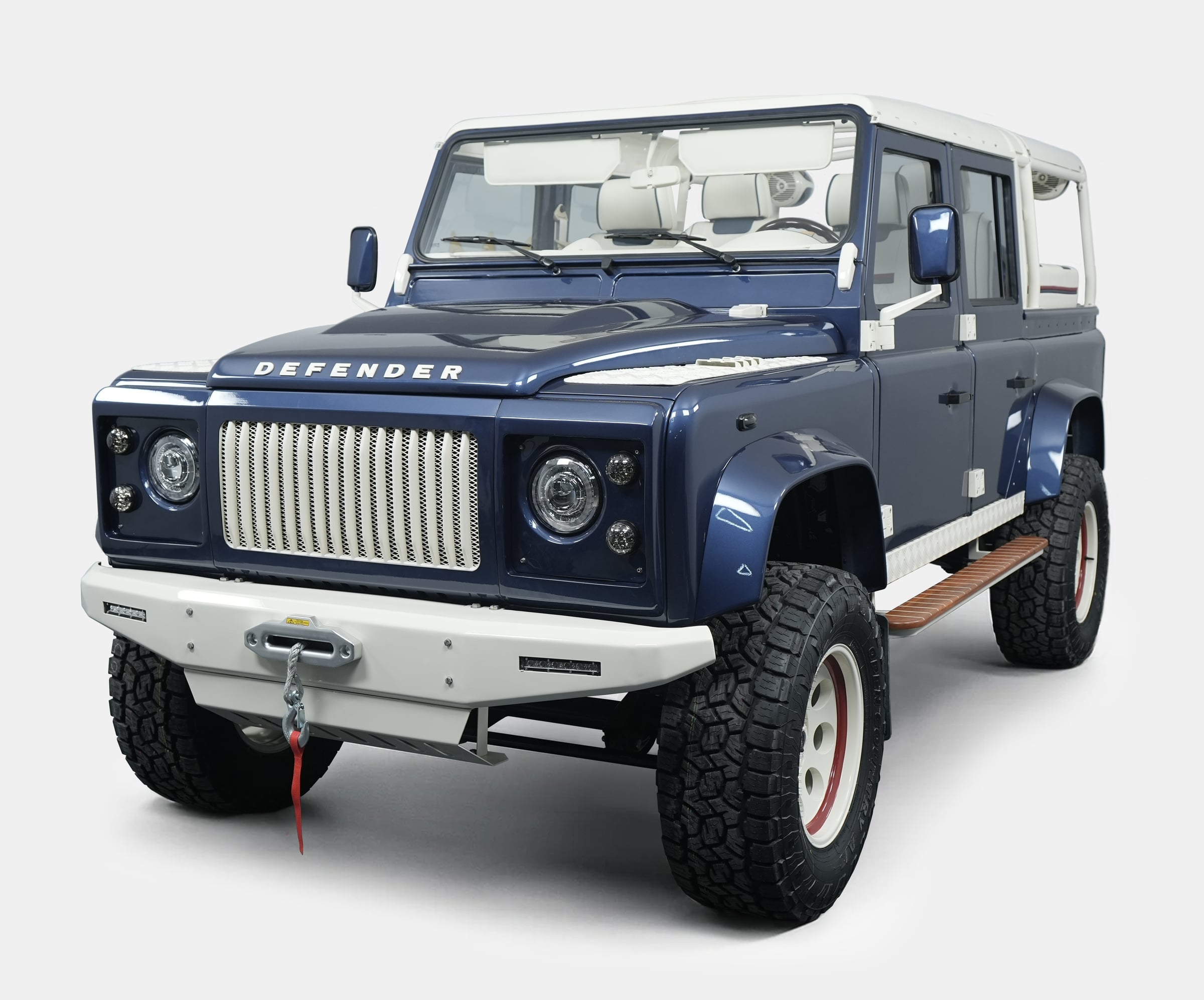 Custom Land Rover Defender in blue with white accents and off-road tires
