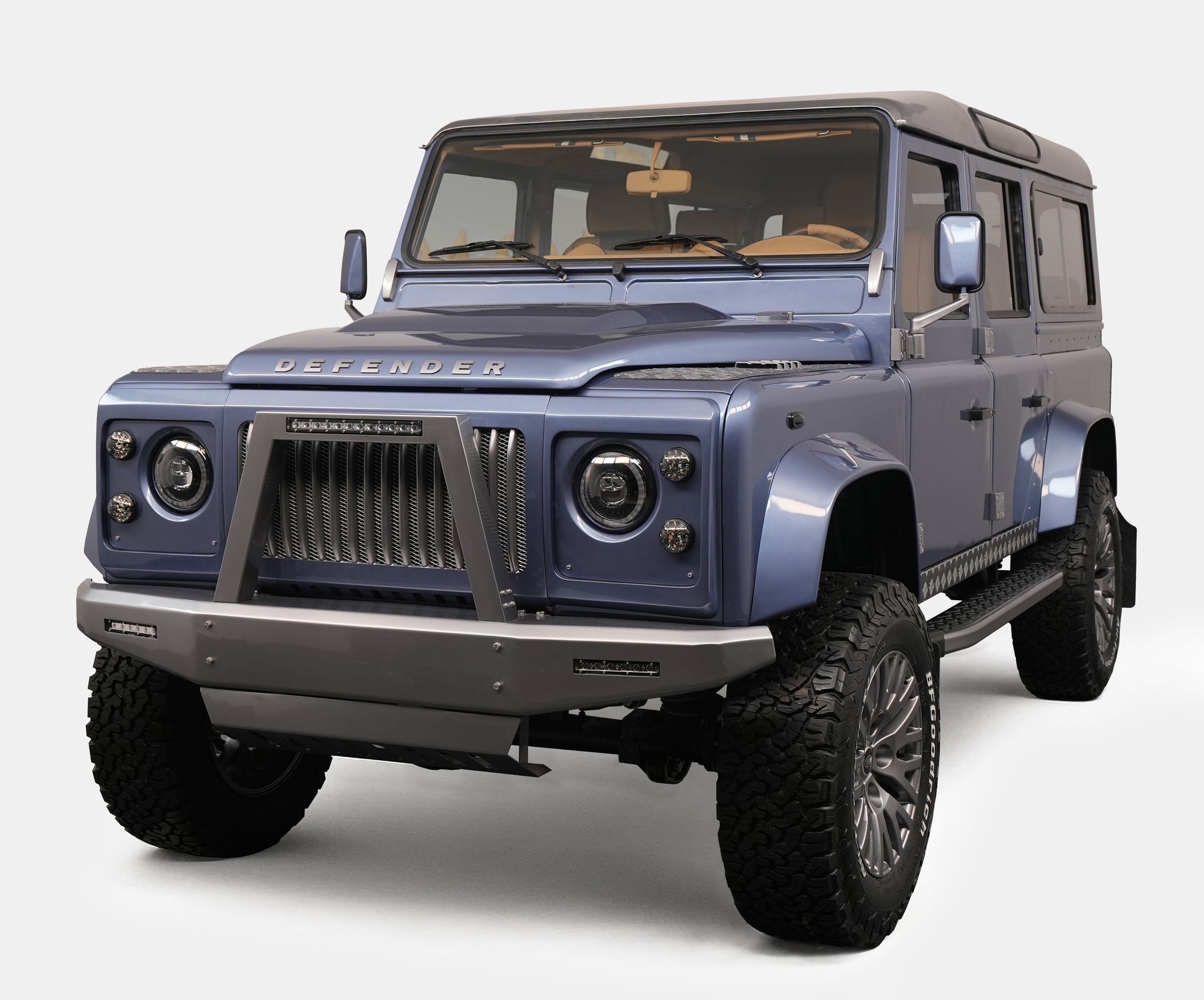 Bespoke Land Rover Defender in a sleek blue finish with rugged tires and modern grille