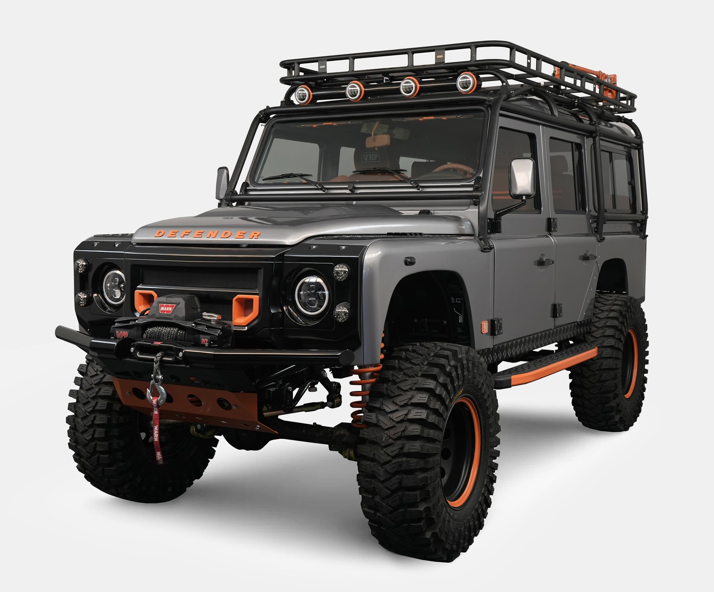 Front view of a bespoke Land Rover Defender with gray exterior and orange accents