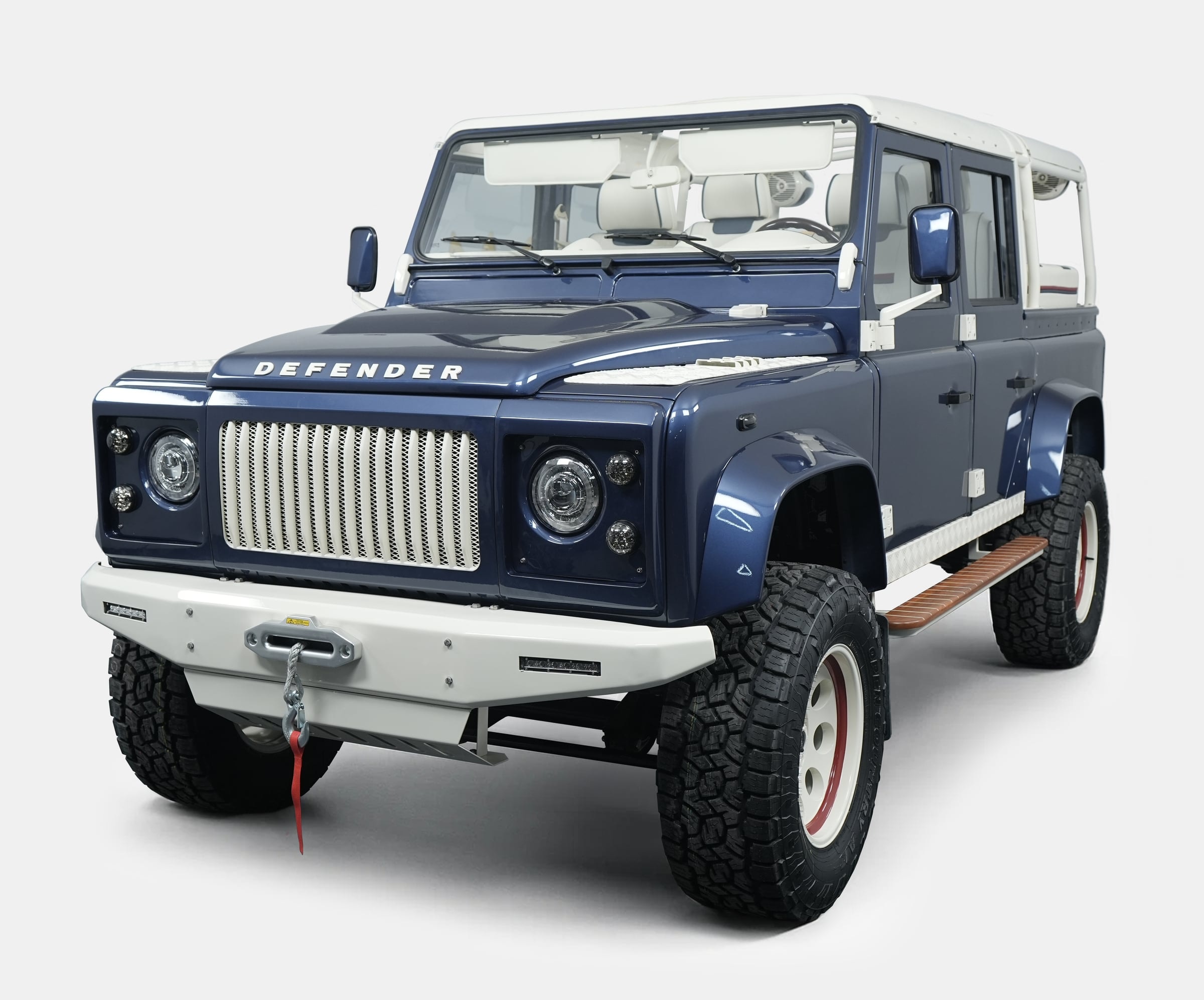 Custom Land Rover Defender in blue with white accents and off-road tires