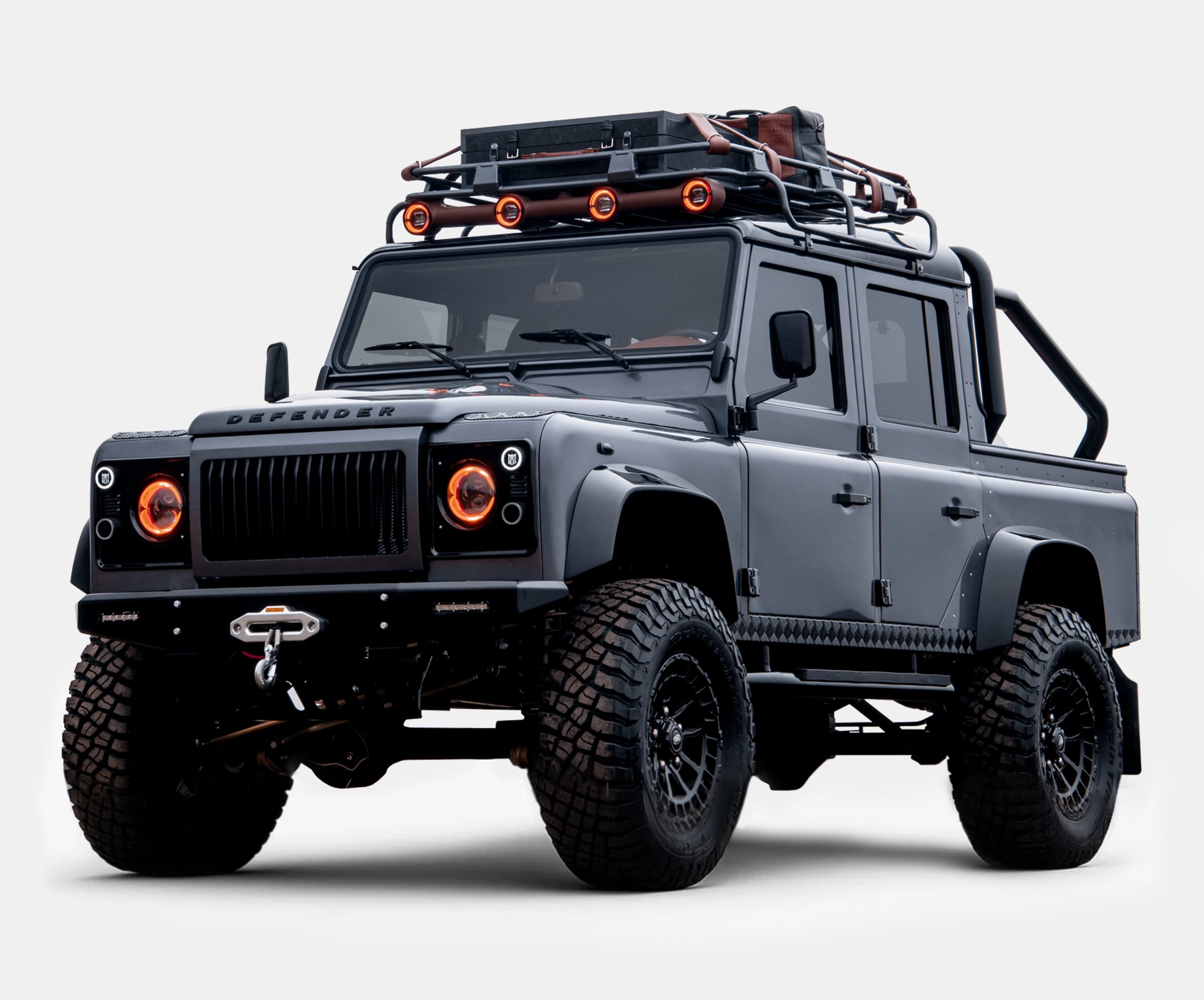 Front view of a custom Land Rover Defender with rugged tires and off-road accessories