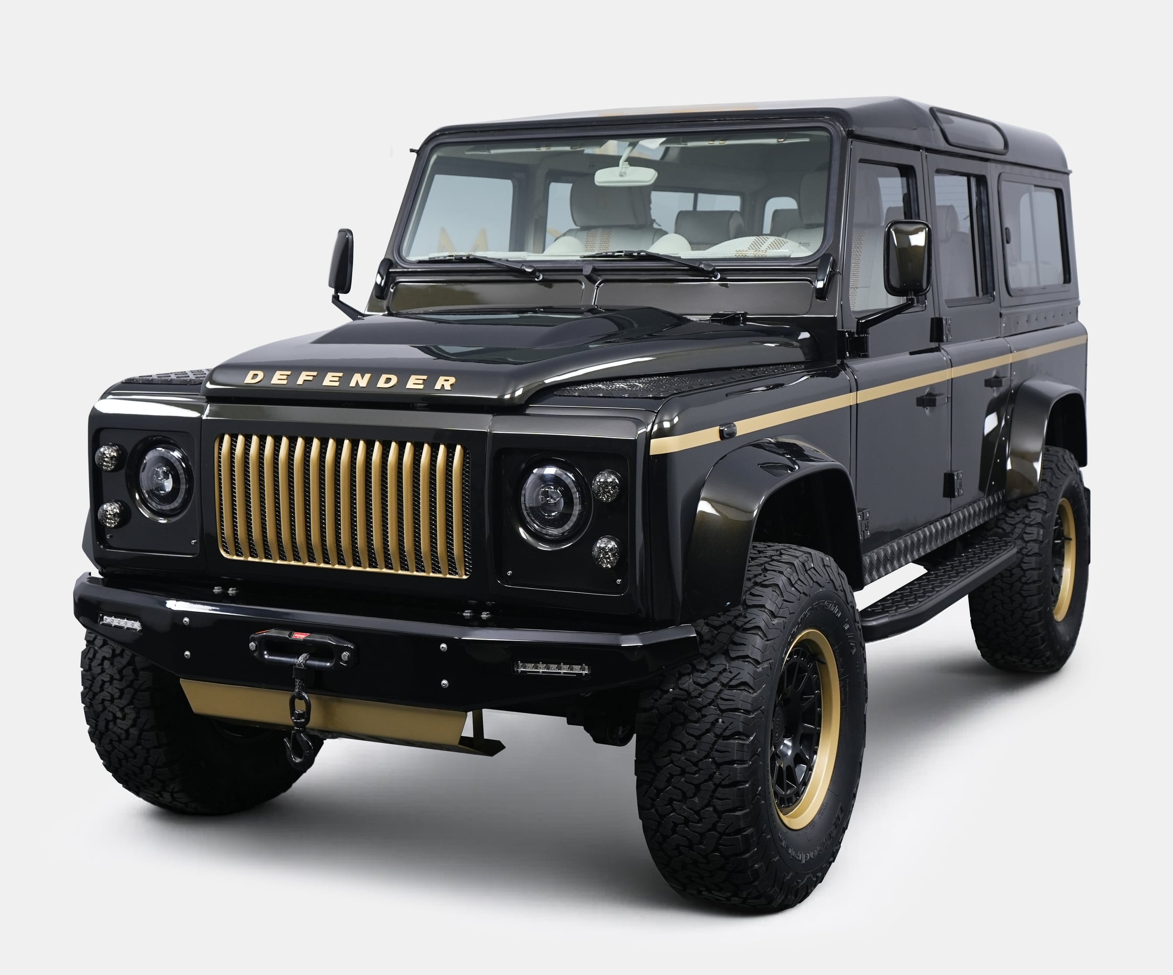 Custom black Land Rover Defender with gold accents and bold grille