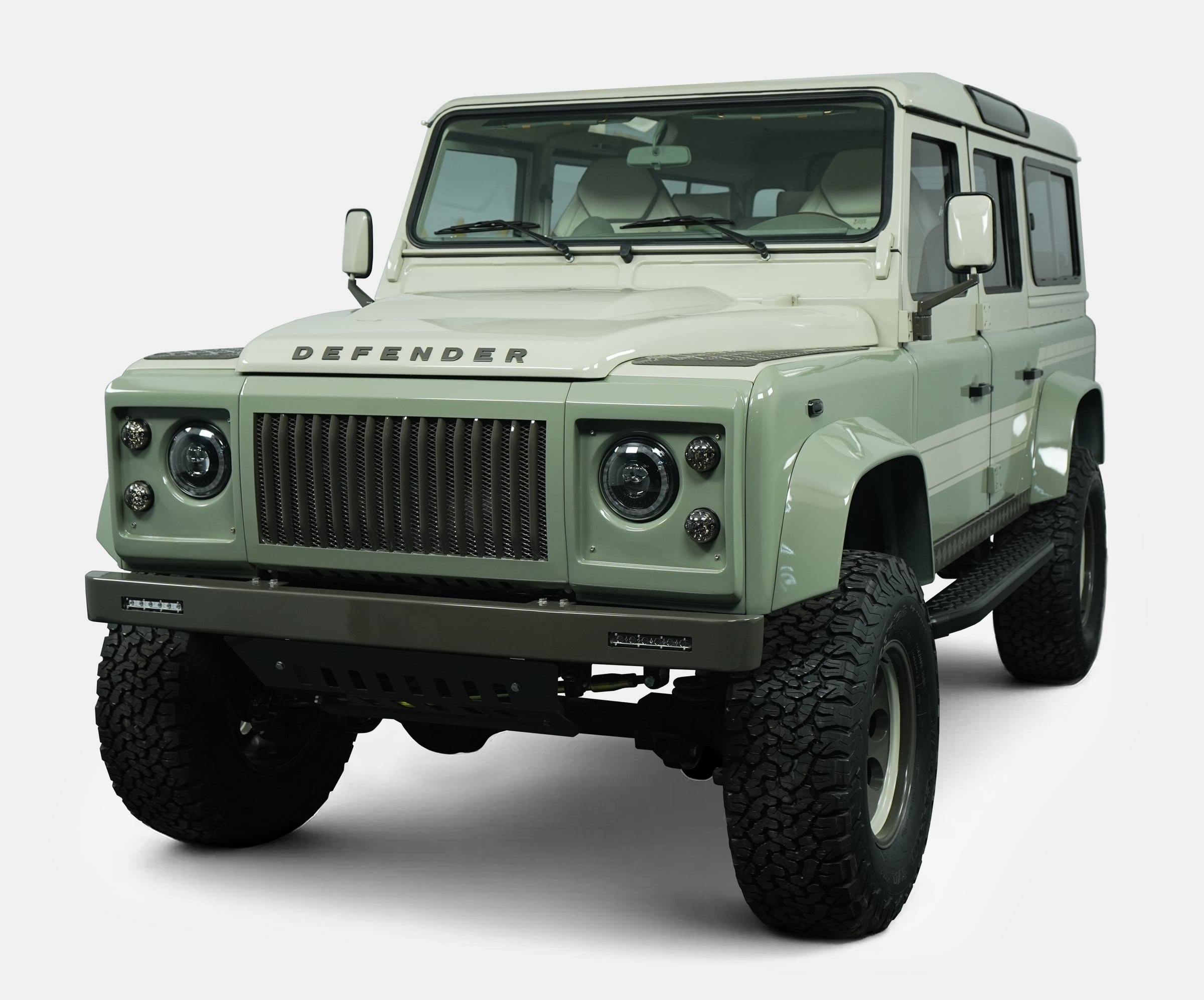 Custom Land Rover Defender in light green with rugged tires