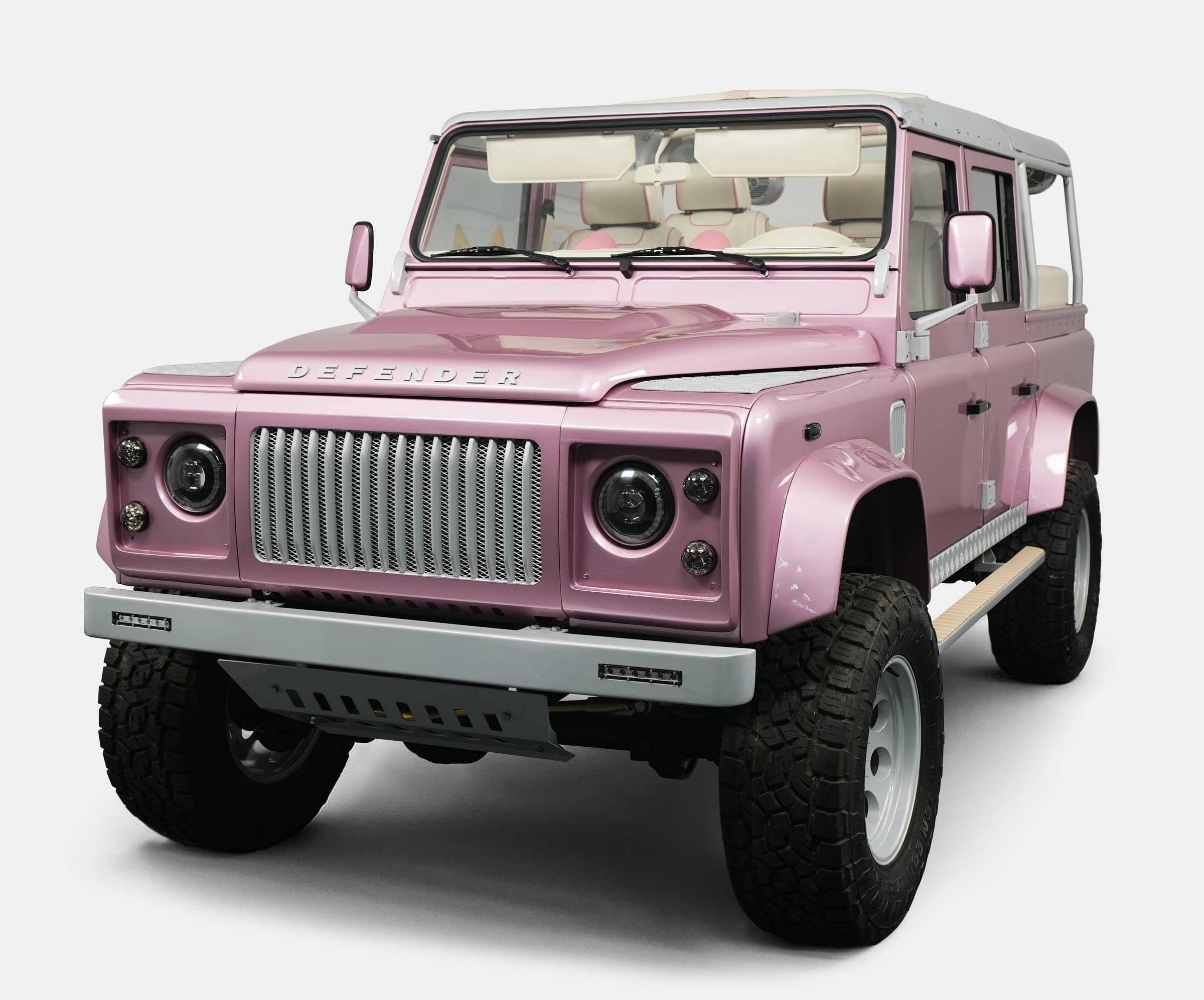 Front view of a bespoke pink Land Rover Defender with modern styling and off-road tires