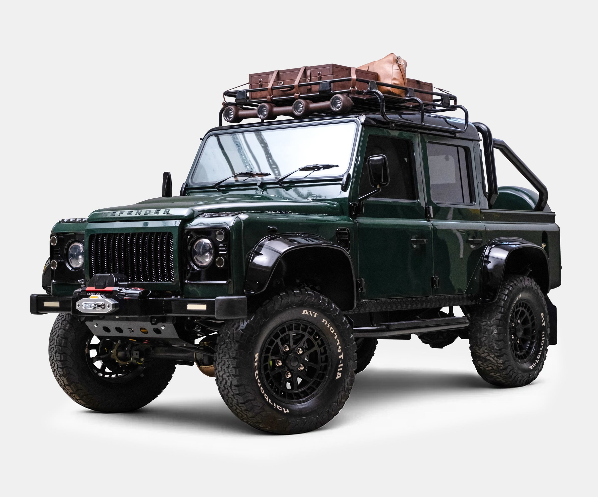 Custom Land Rover Defender in dark green with rooftop luggage