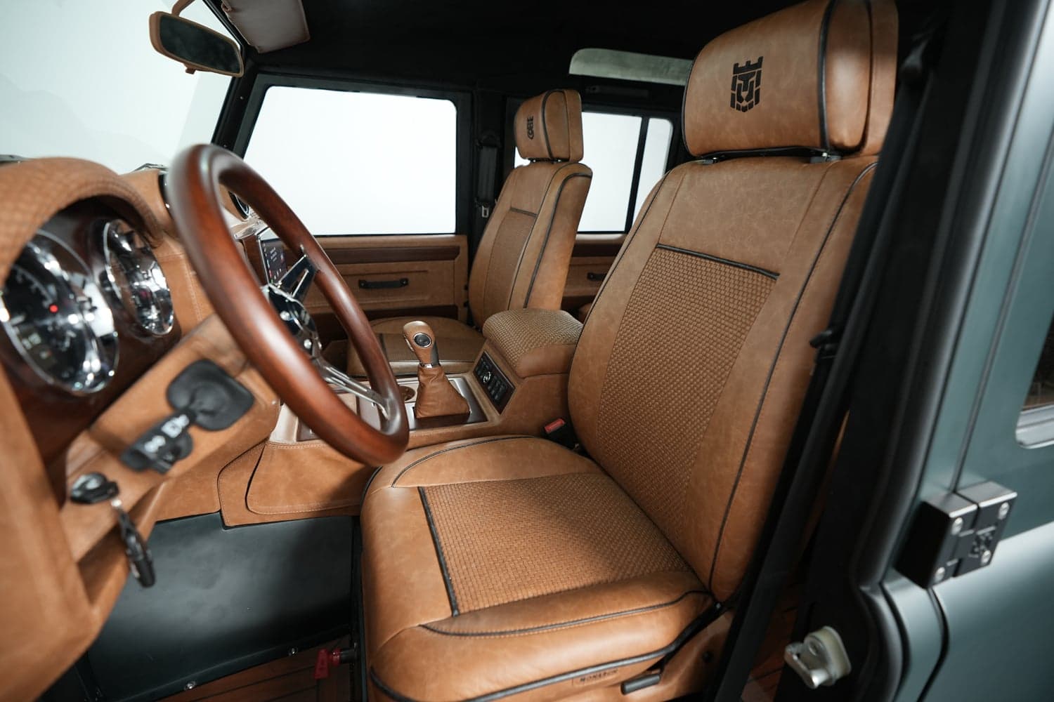 Interior Shot: Luxurious Cabin Interior view of a luxury Land Rover Defender with tan leather seats and wooden steering wheel