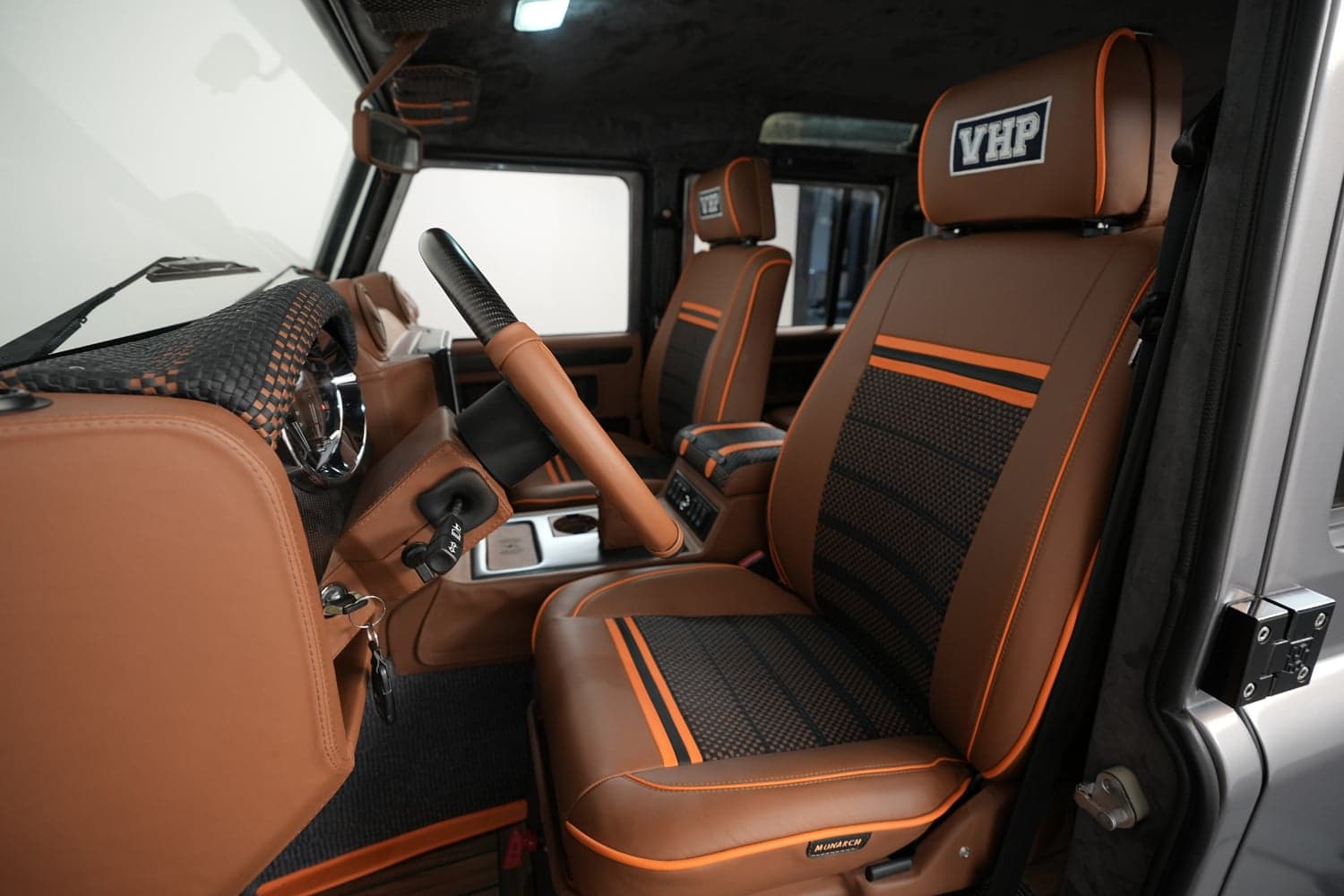 Interior Shot: Luxury Cabin Design Interior view of a custom Land Rover Defender with brown leather seats and orange accents