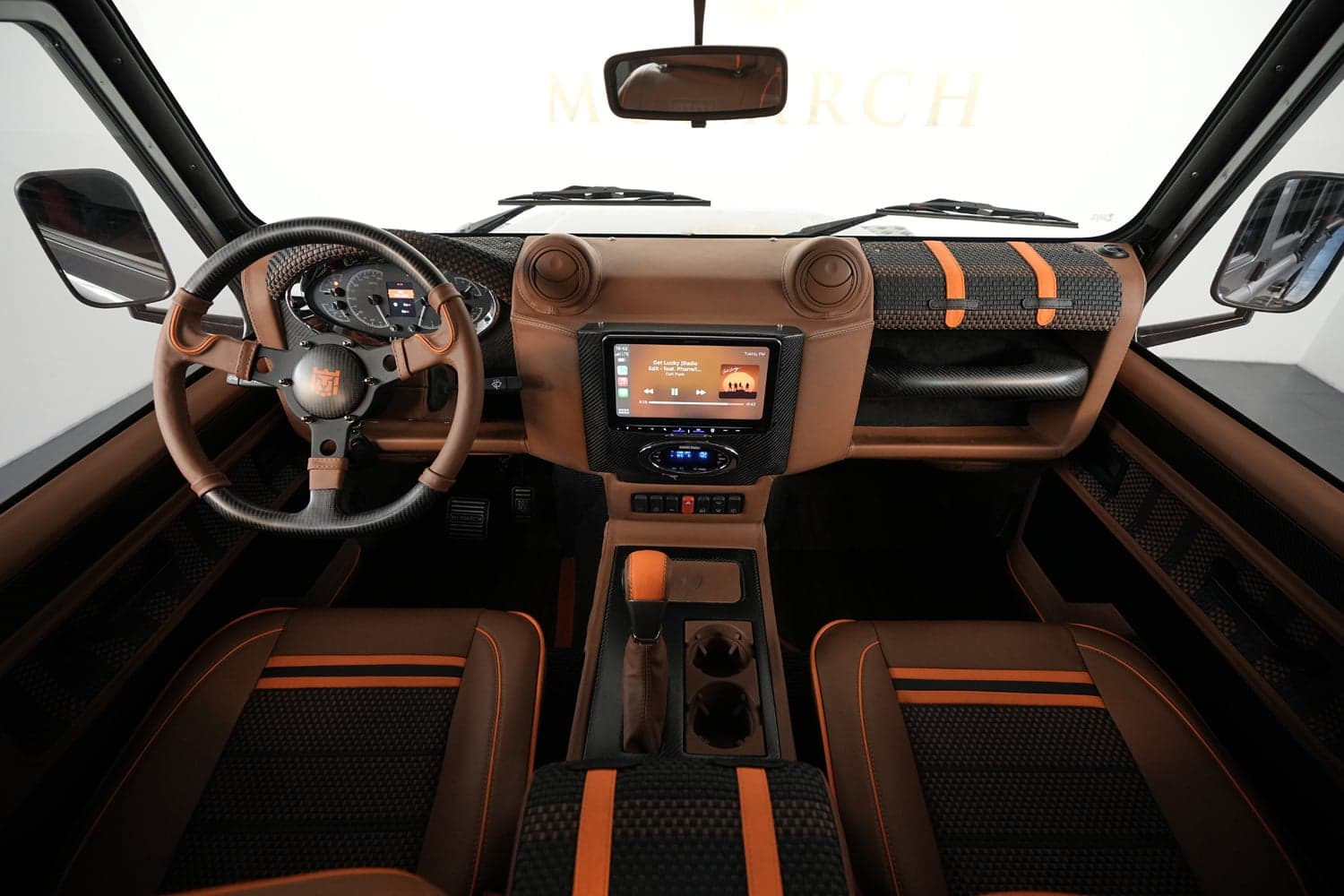 Interior Shot: Custom Cabin Design Luxury custom Land Rover Defender interior with brown and orange accents