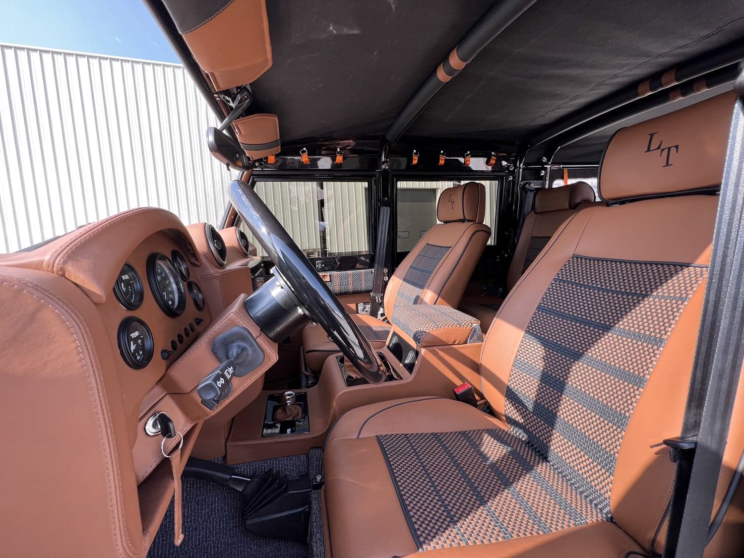 Interior Shot: Luxury Cabin Interior view of a bespoke Land Rover Defender featuring premium tan leather seats and dashboard