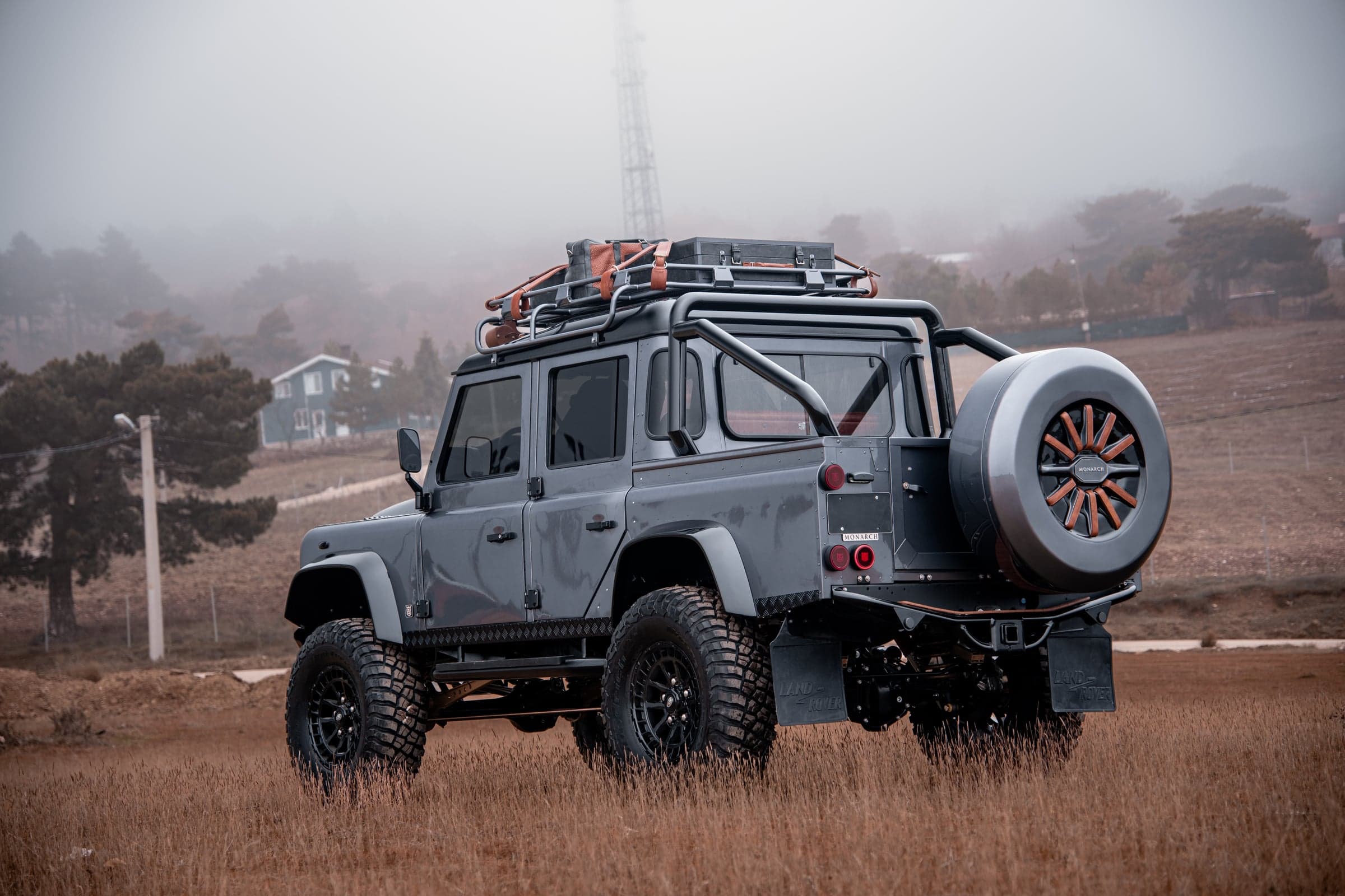 Rear View: Bespoke Land Rover Defender Custom Land Rover Defender in grey with off-road tires and roof rack