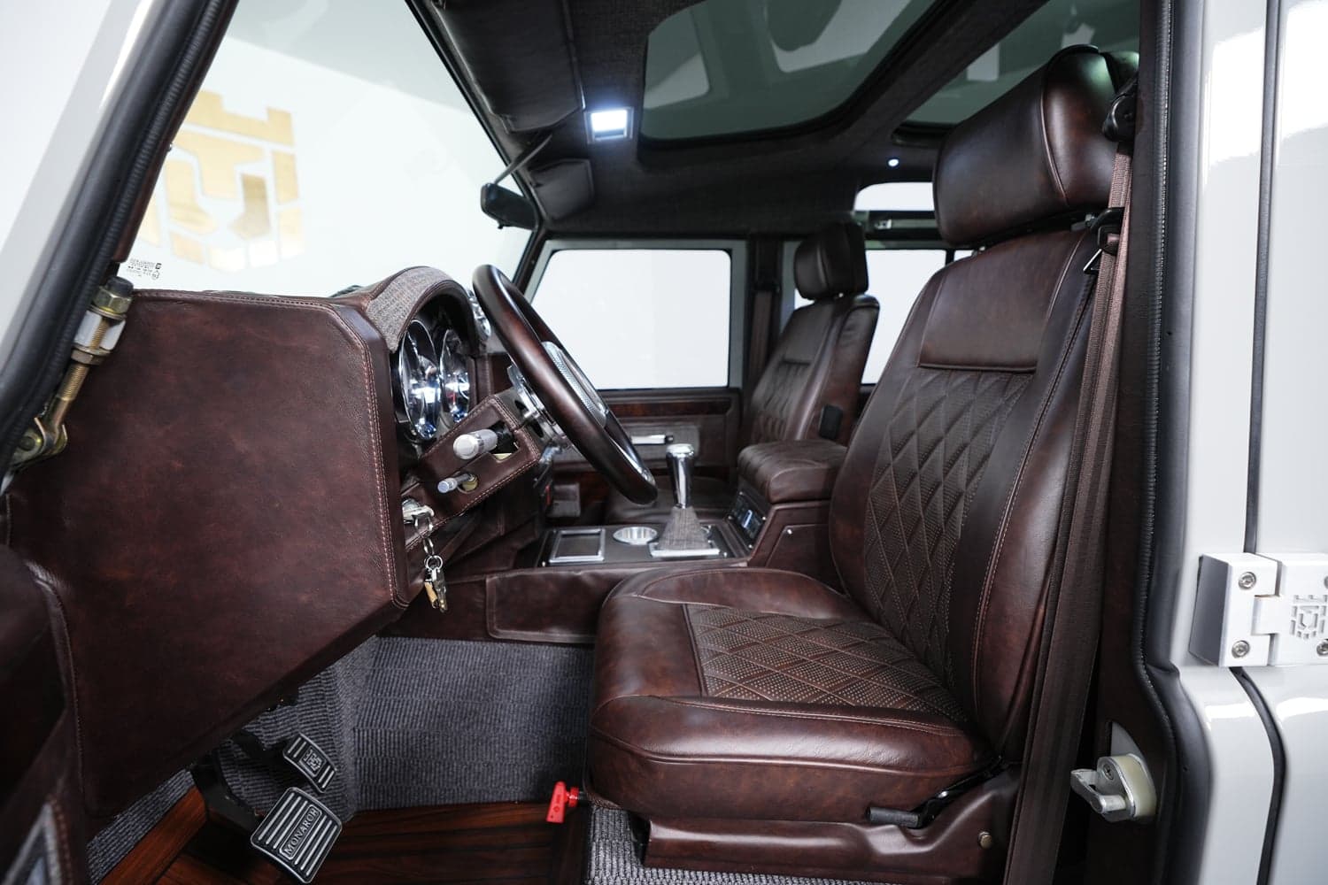 Interior Shot: Luxury Cabin Bespoke Land Rover Defender interior featuring premium brown leather seats and dashboard