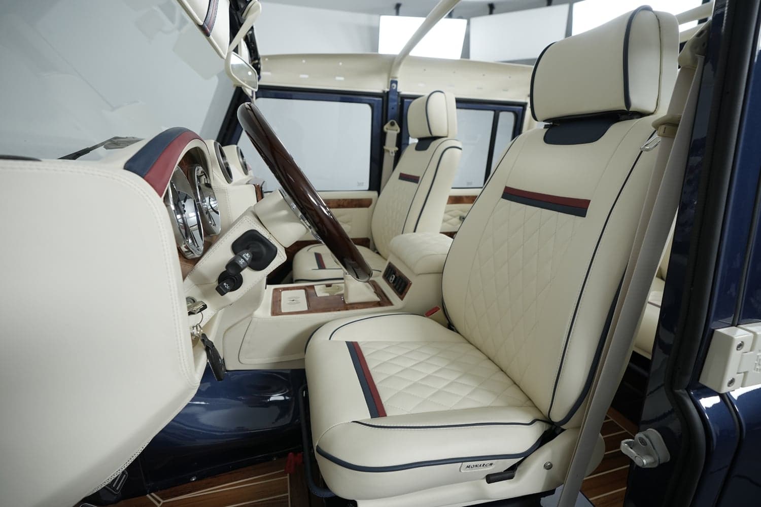 Interior Shot: Luxury Cabin Bespoke interior of a custom Land Rover Defender featuring quilted leather seats and elegant wood accents.