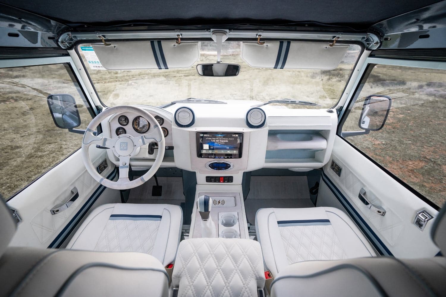 Interior Shot: Luxury Cabin Bespoke Land Rover Defender interior featuring white leather seats and modern dashboard