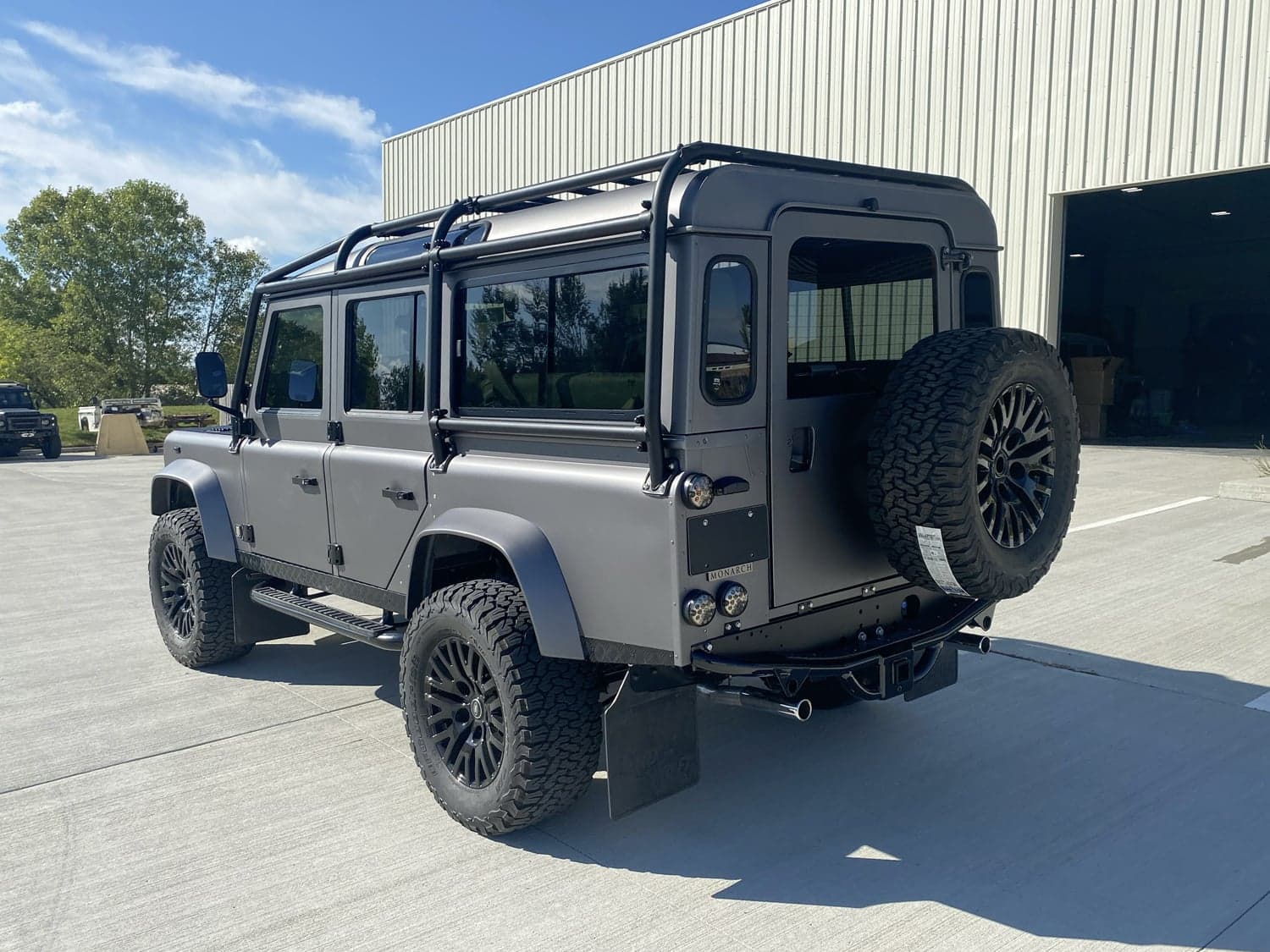 Rear View: Custom Land Rover Defender Rear view of a bespoke Land Rover Defender with matte finish and off-road tires