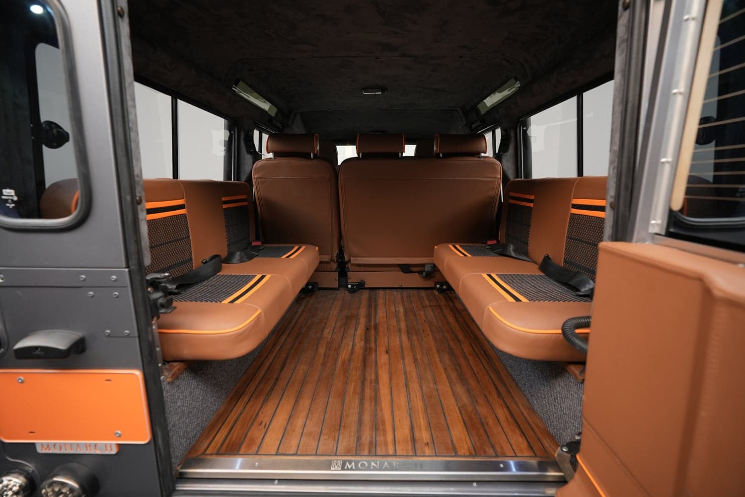 Interior Shot: Luxury Cabin Space Interior of a custom Land Rover Defender with brown leather seats and wooden flooring