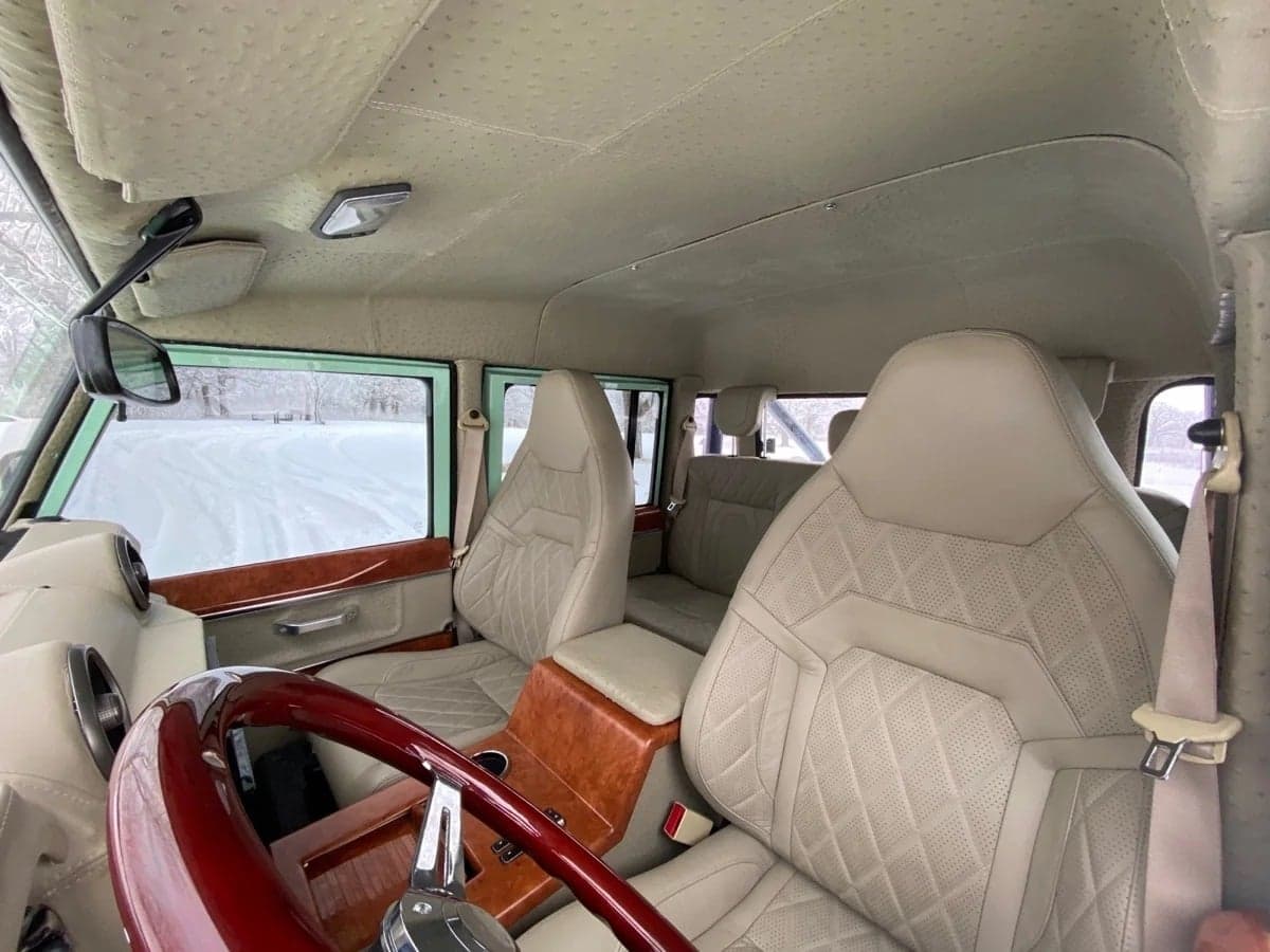 Interior Shot: Luxurious Cabin Interior view of a custom Land Rover Defender featuring premium leather seats and wood accents