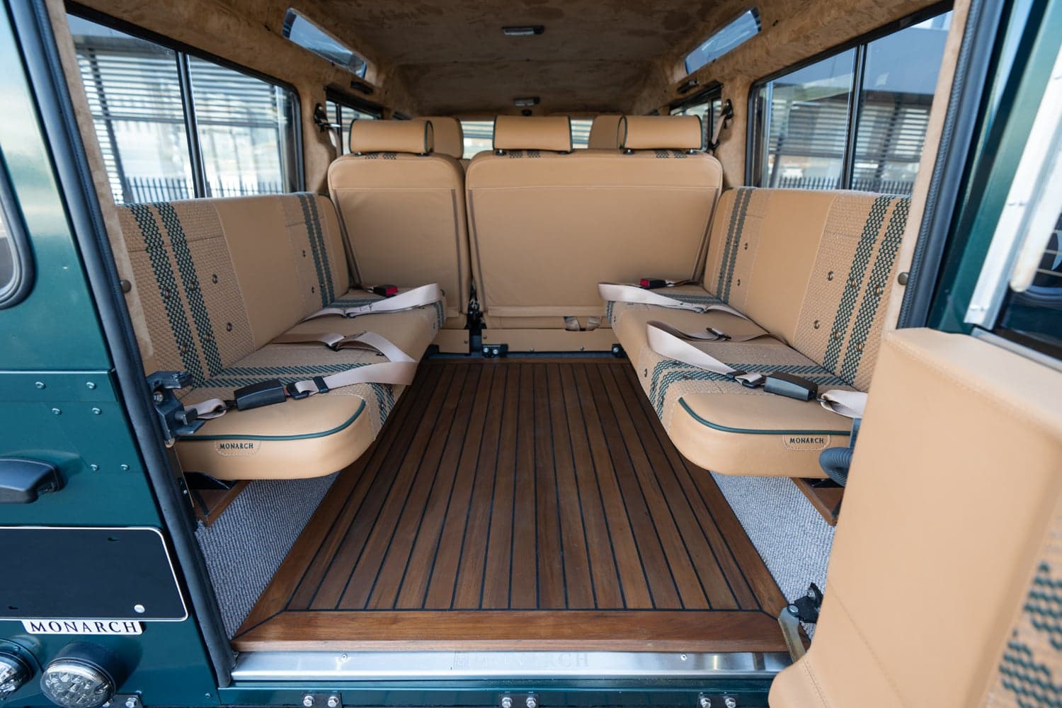 Interior Shot: Luxury Cabin Interior of a custom Land Rover Defender with tan upholstery and wooden flooring
