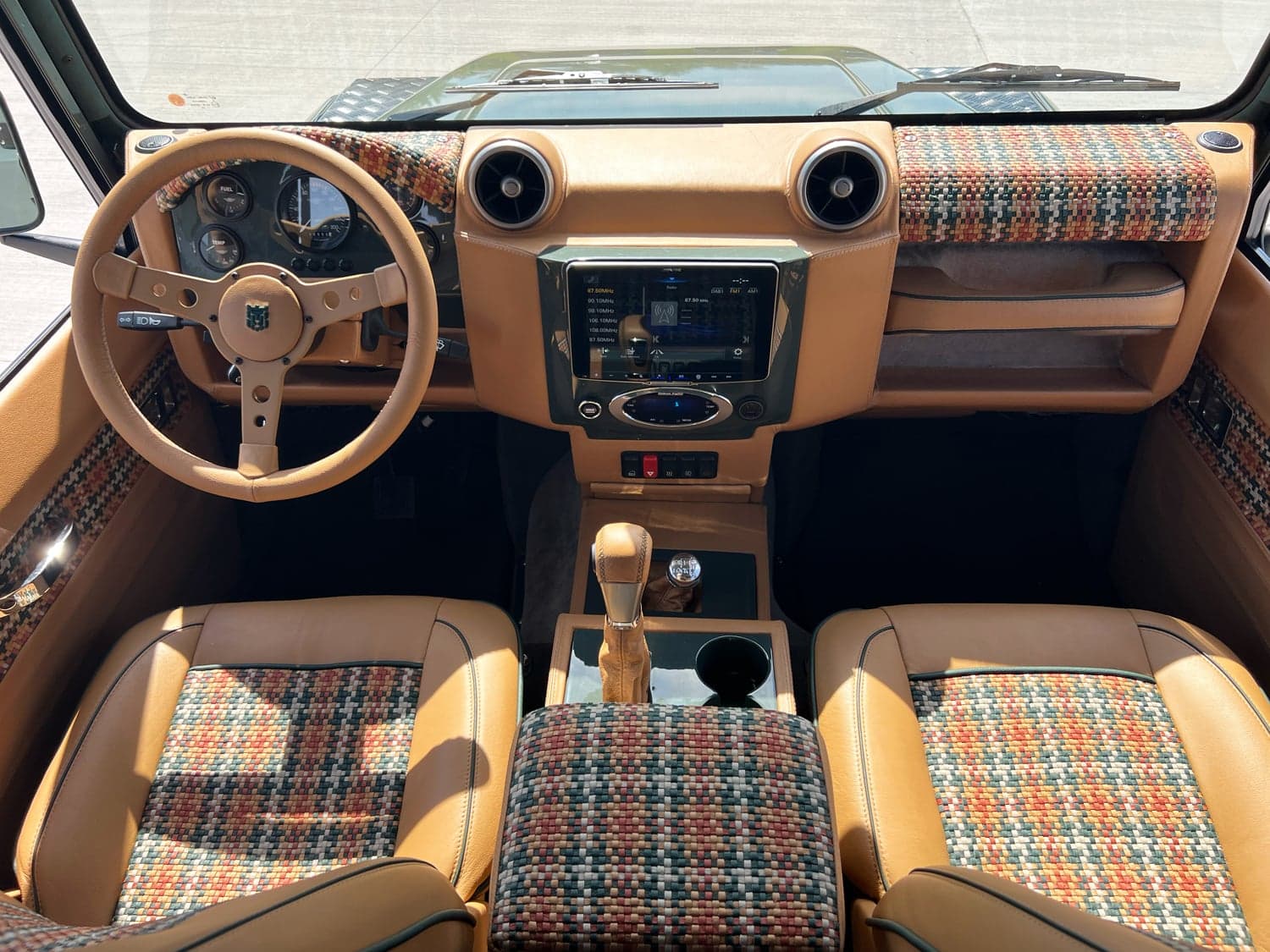Interior Shot: Custom Land Rover Defender Cabin Luxury interior of a custom Land Rover Defender featuring premium materials and modern technology