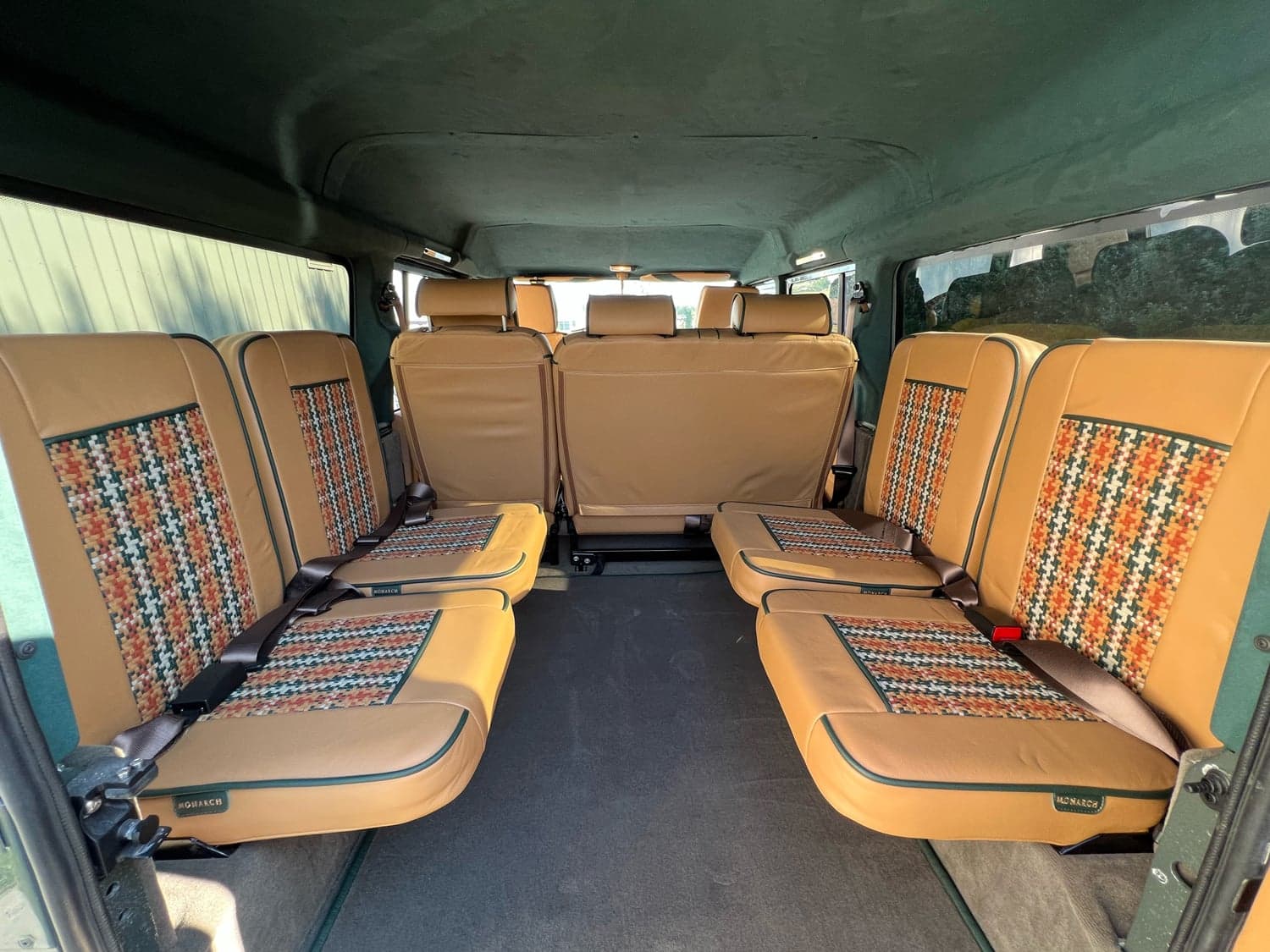 Interior Shot: Luxury Cabin Interior of a custom Land Rover Defender showcasing premium tan seating and patterned upholstery