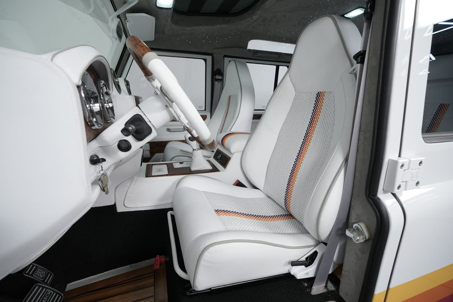 Interior Shot: Premium Cabin Interior view of a luxury custom Land Rover Defender featuring white leather seats and modern dashboard design