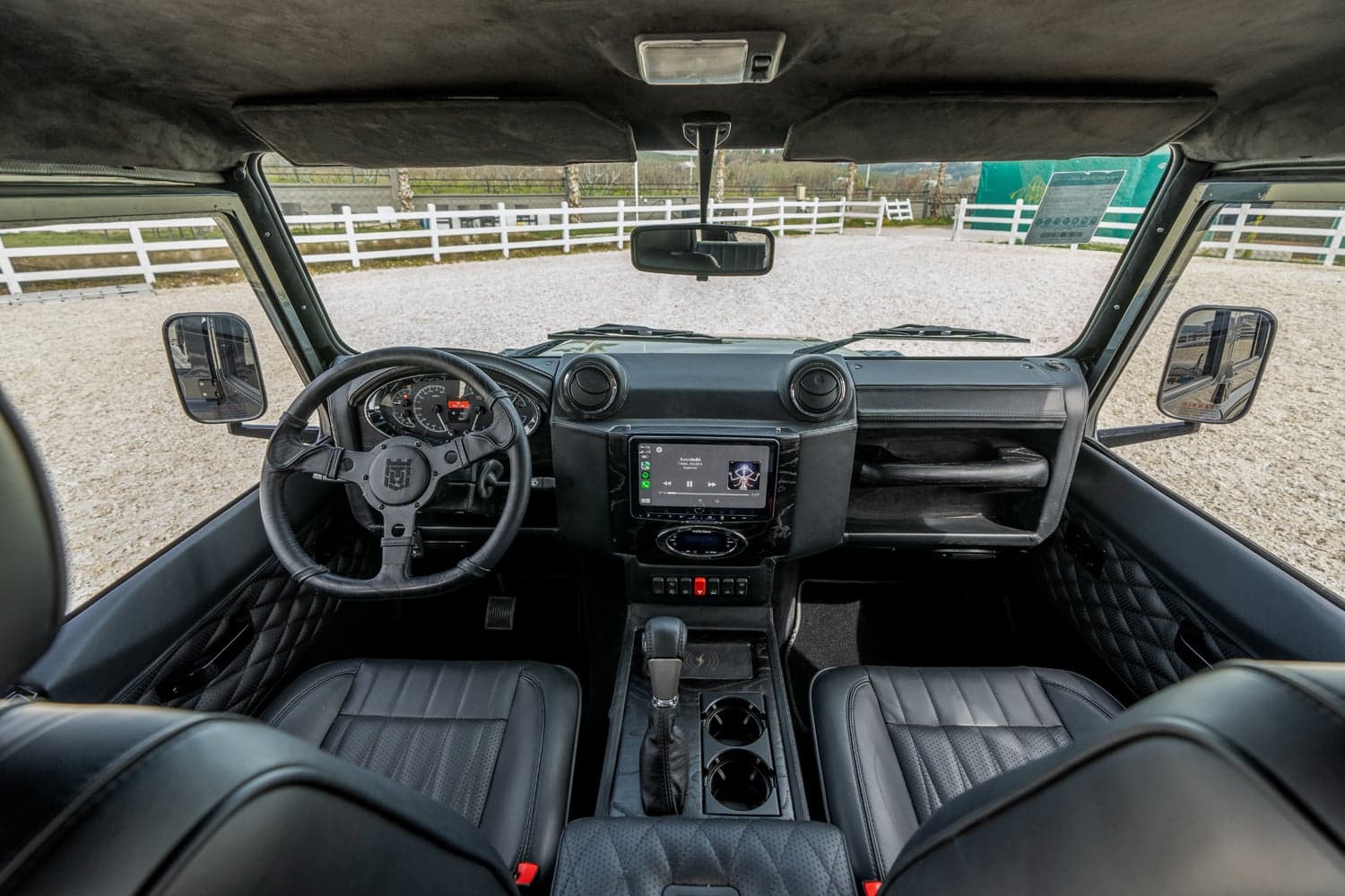 Interior Shot: Luxury Cabin Interior view of a bespoke Land Rover Defender showcasing premium black leather seats and modern dashboard features
