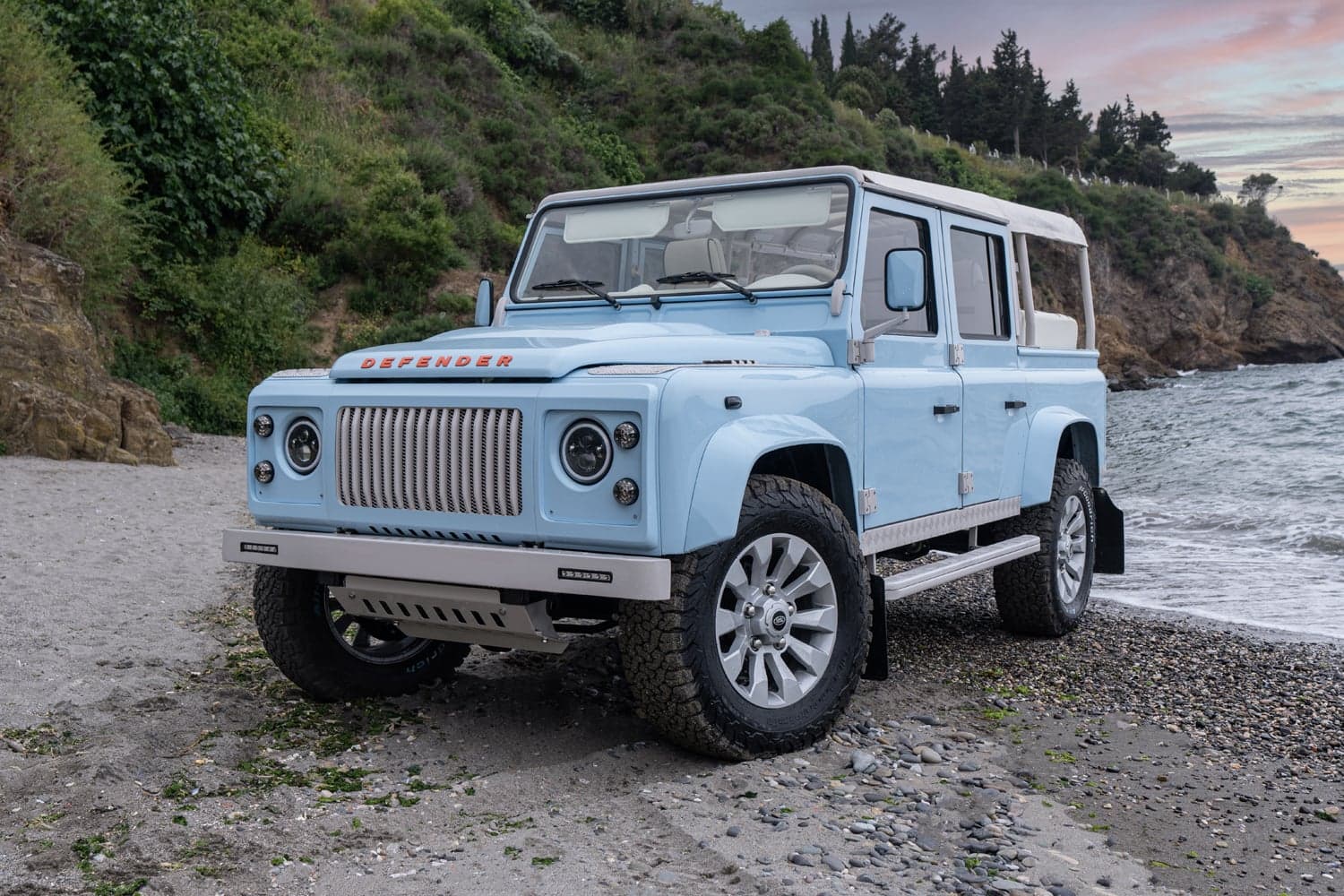 Front View: Bespoke Land Rover Defender Light blue custom Land Rover Defender parked on a beach
