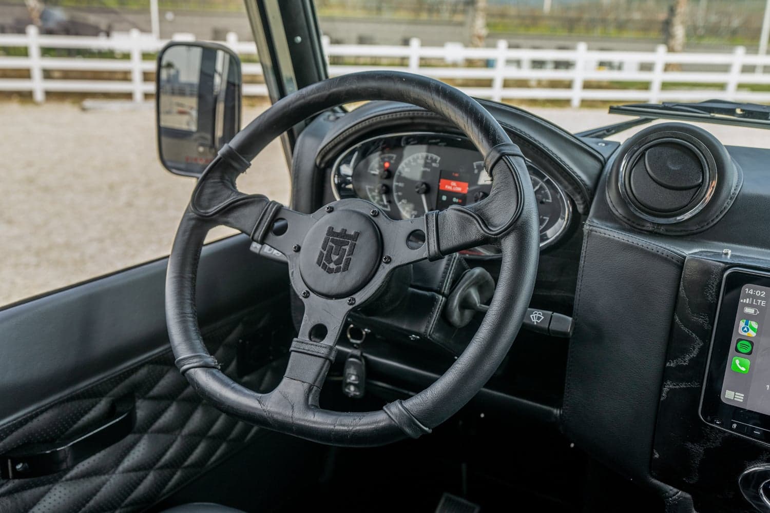 Interior Shot: Custom Steering Wheel Close-up view of a luxury Land Rover Defender's custom steering wheel and dashboard