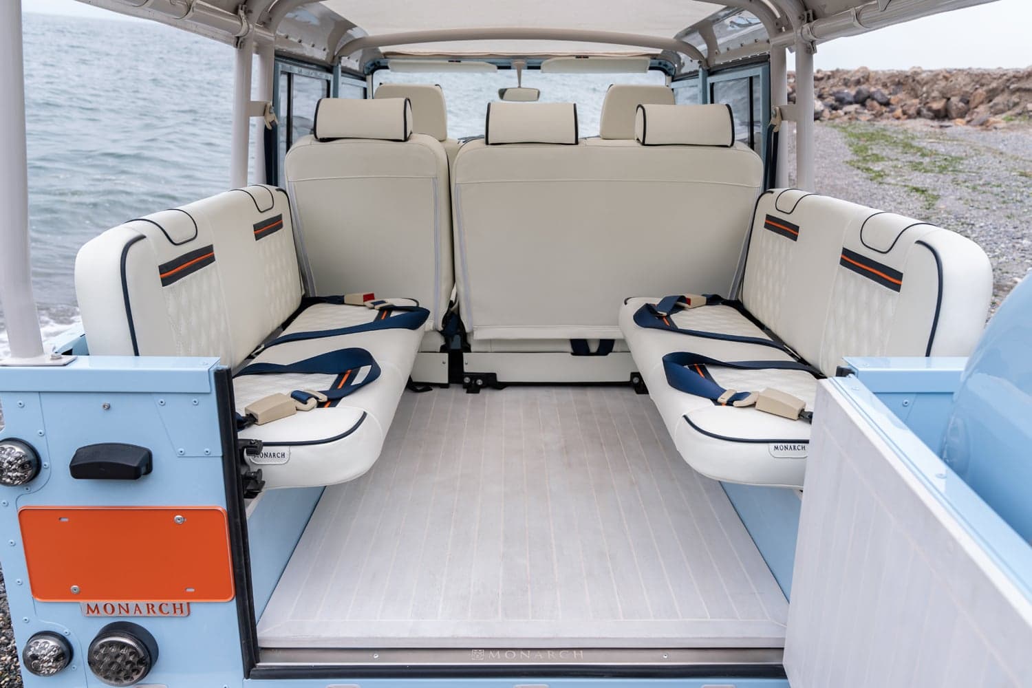 Interior Shot: Luxury Cabin Space Interior view of a bespoke Land Rover Defender with white leather seats and blue accents