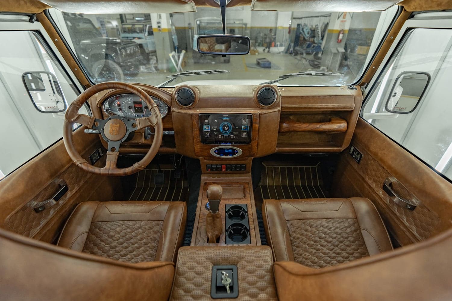 Interior Shot: Luxurious Cabin Design Interior view of a custom Land Rover Defender with premium leather upholstery and modern dashboard features