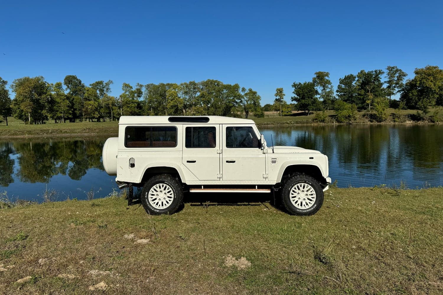 Side View: Bespoke Land Rover Defender Custom Land Rover Defender parked by a serene lake