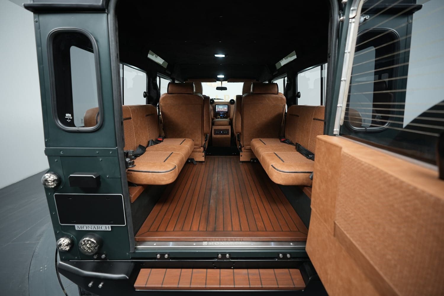 Interior Shot: Luxury Cabin Space Interior view of a custom Land Rover Defender showing luxurious seating and wooden flooring