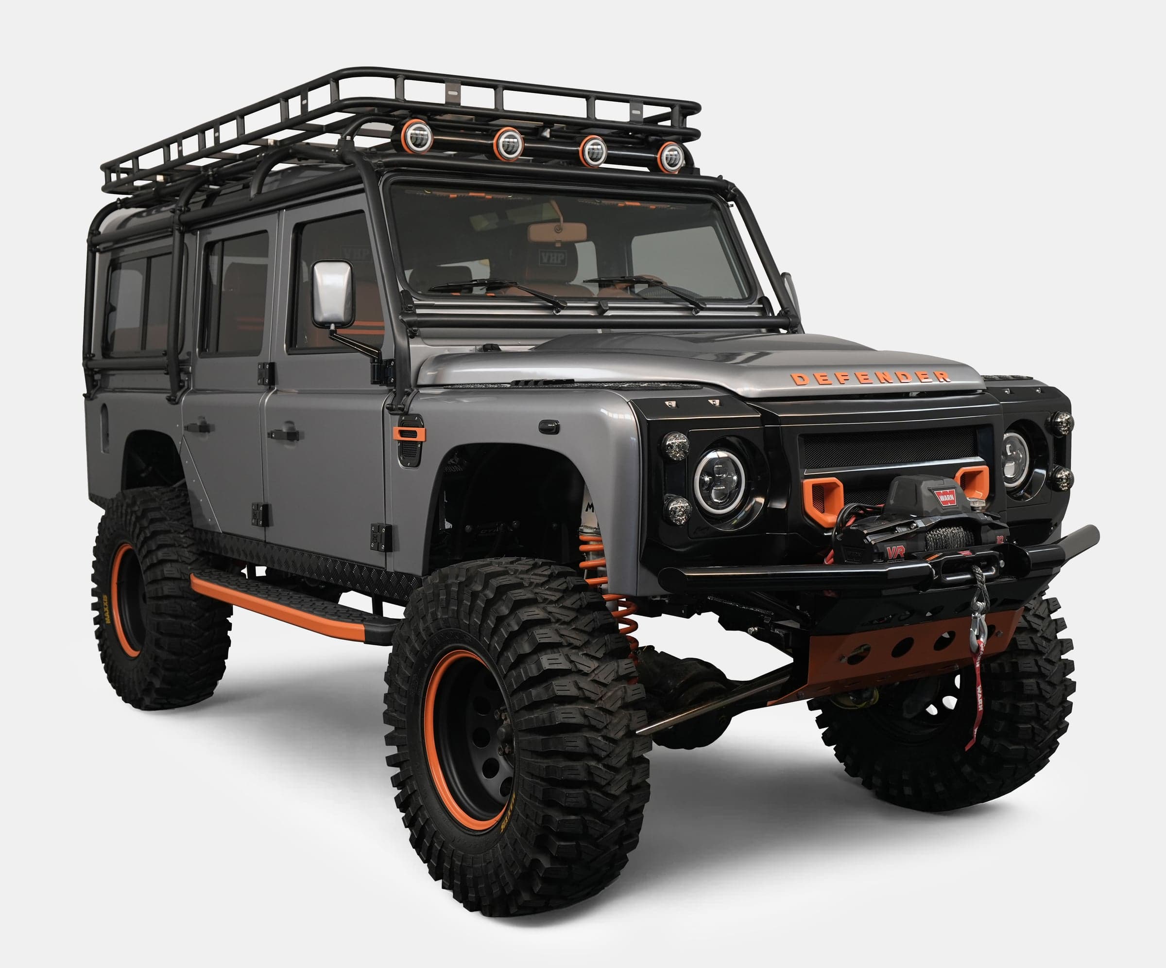 Front View: Bespoke Land Rover Defender Custom Land Rover Defender in grey with orange accents and off-road tires