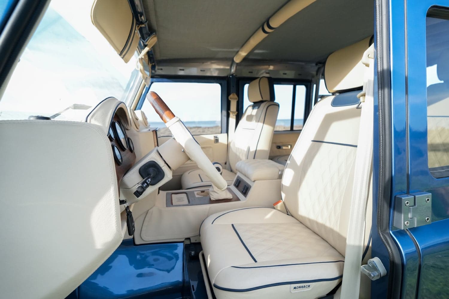 Interior Shot: Luxury Cabin Interior view of a bespoke Land Rover Defender with cream leather seats and wooden accents