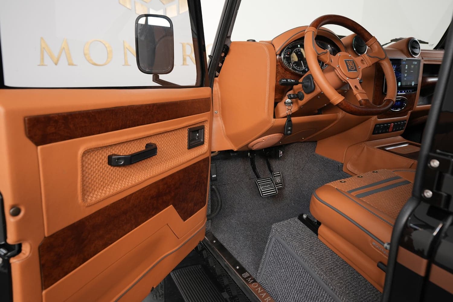 Interior Shot: Luxury Cabin Close-up of a luxury Land Rover Defender interior featuring tan leather and wood accents