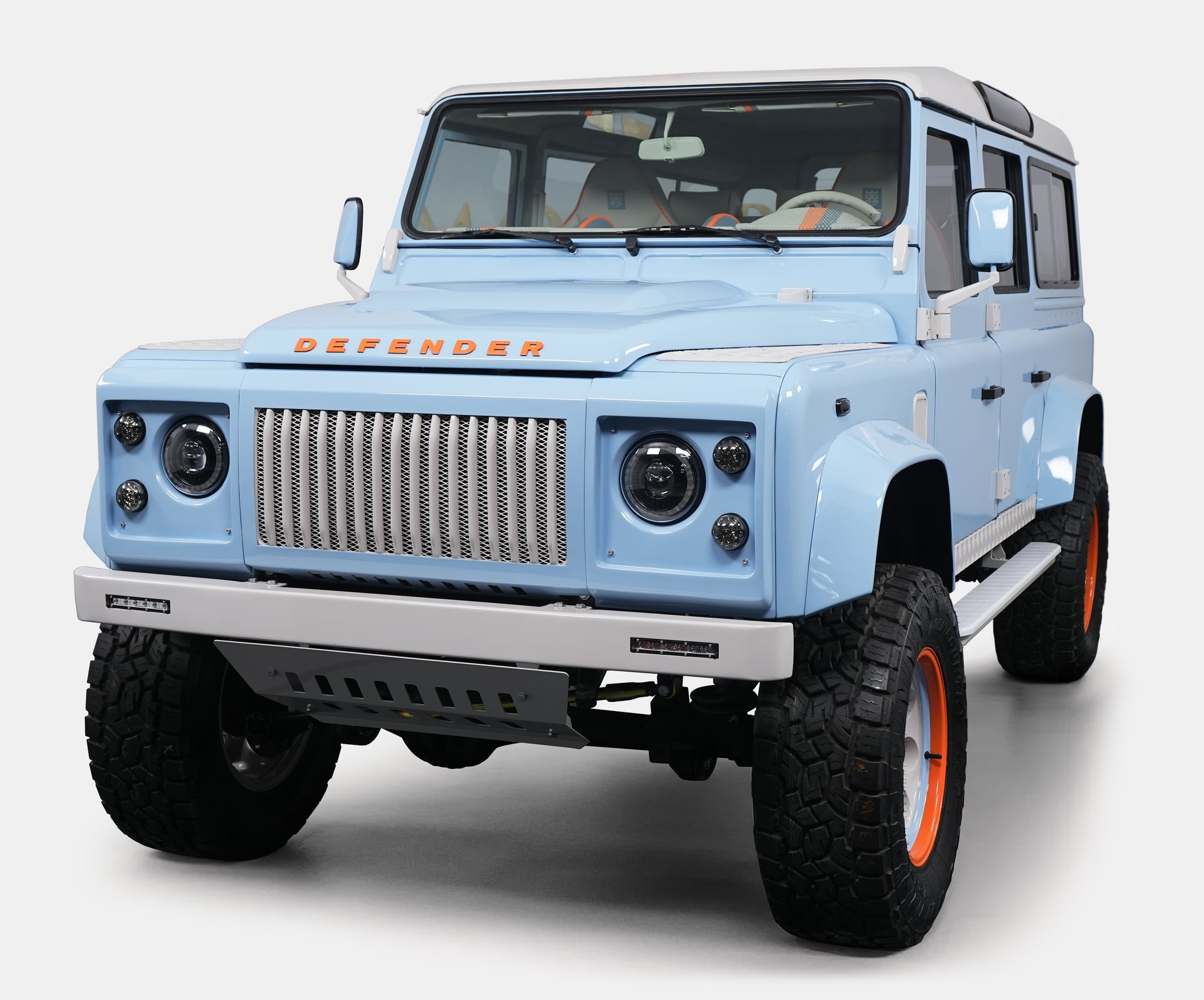 Front View: Custom Land Rover Defender Custom Land Rover Defender in light blue with orange accents and rugged tires