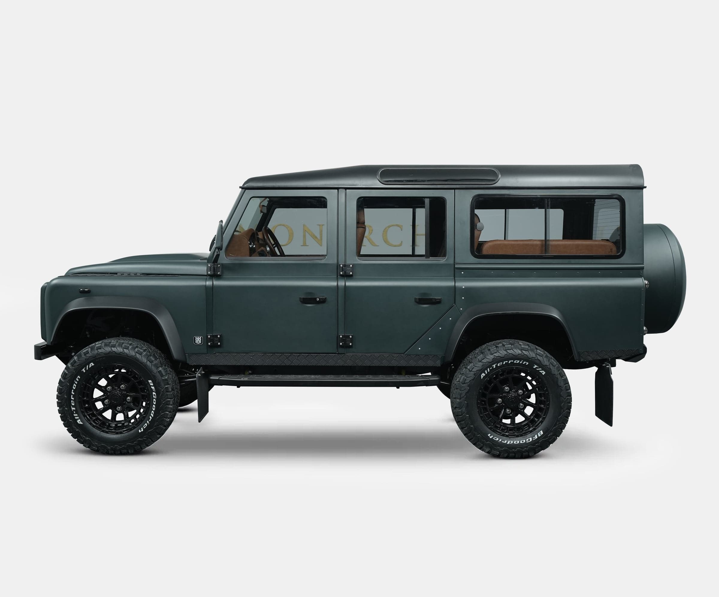 Side View: Bespoke Land Rover Defender Custom Land Rover Defender in dark green with off-road tires