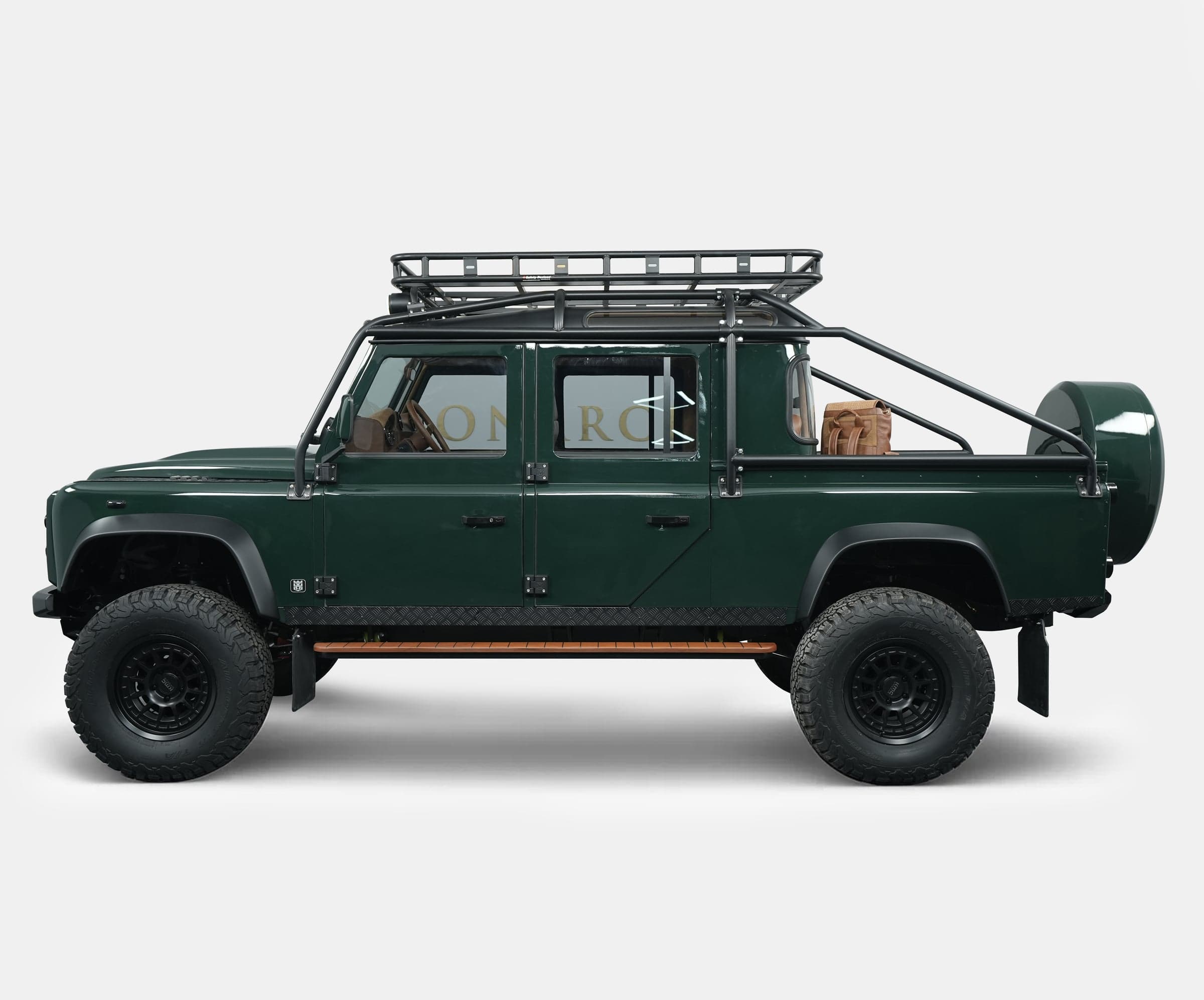 Side View: Bespoke Land Rover Defender Side profile of a custom Land Rover Defender in green with off-road features