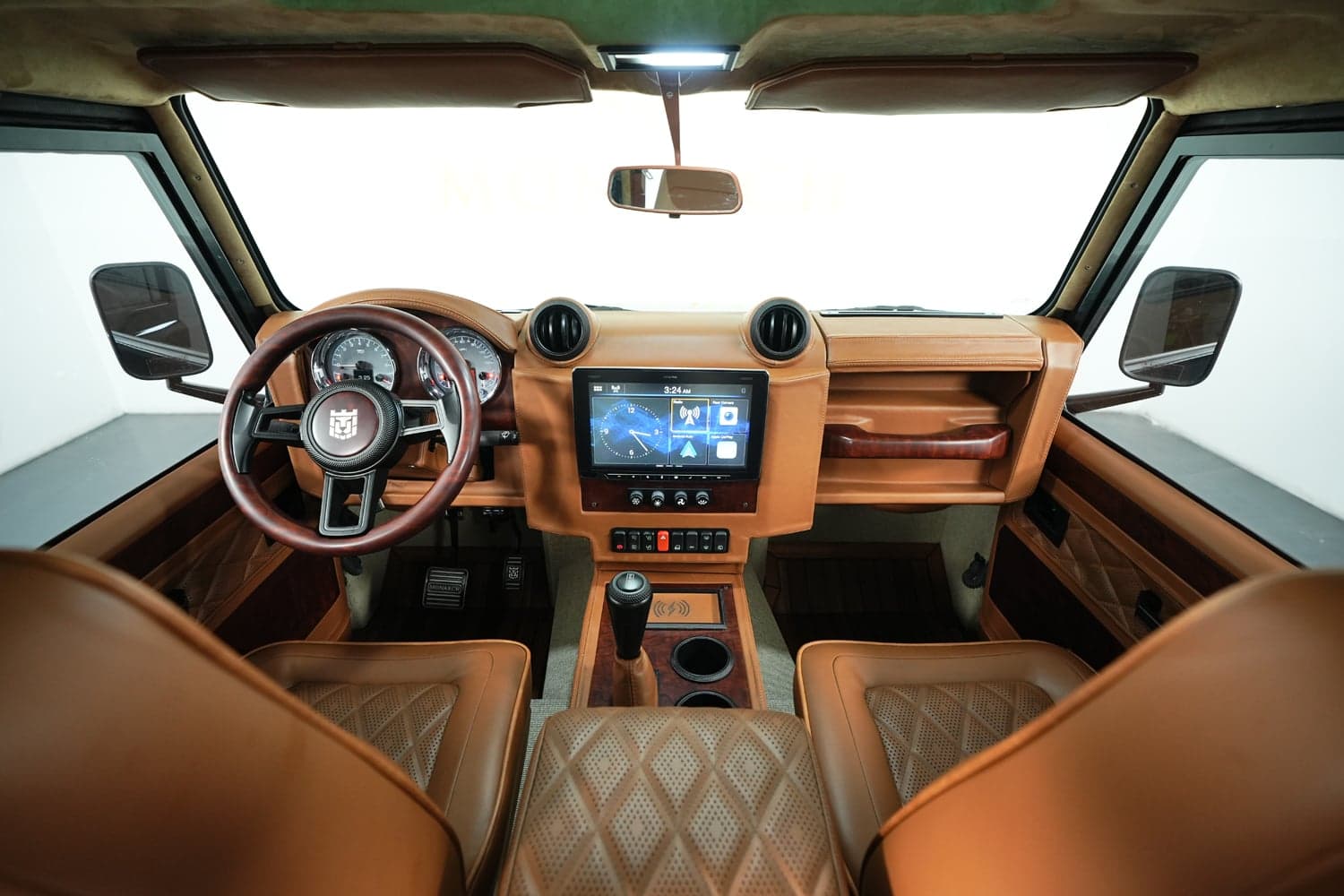 Interior Shot: Luxurious Cabin Design Interior view of a custom Land Rover Defender featuring premium tan leather seats and modern technology