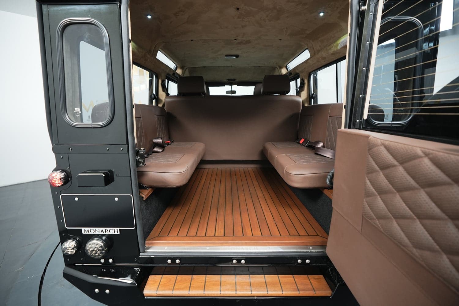 Interior Shot: Luxury Cabin Interior view of a custom Land Rover Defender featuring brown leather seating and wooden flooring