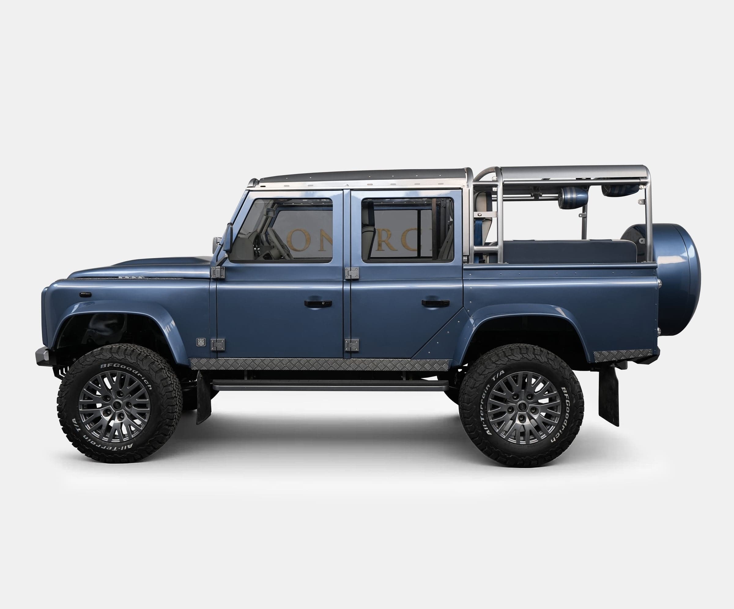 Side View: Custom Land Rover Defender Bespoke Land Rover Defender in blue with rugged tires and stainless steel accents